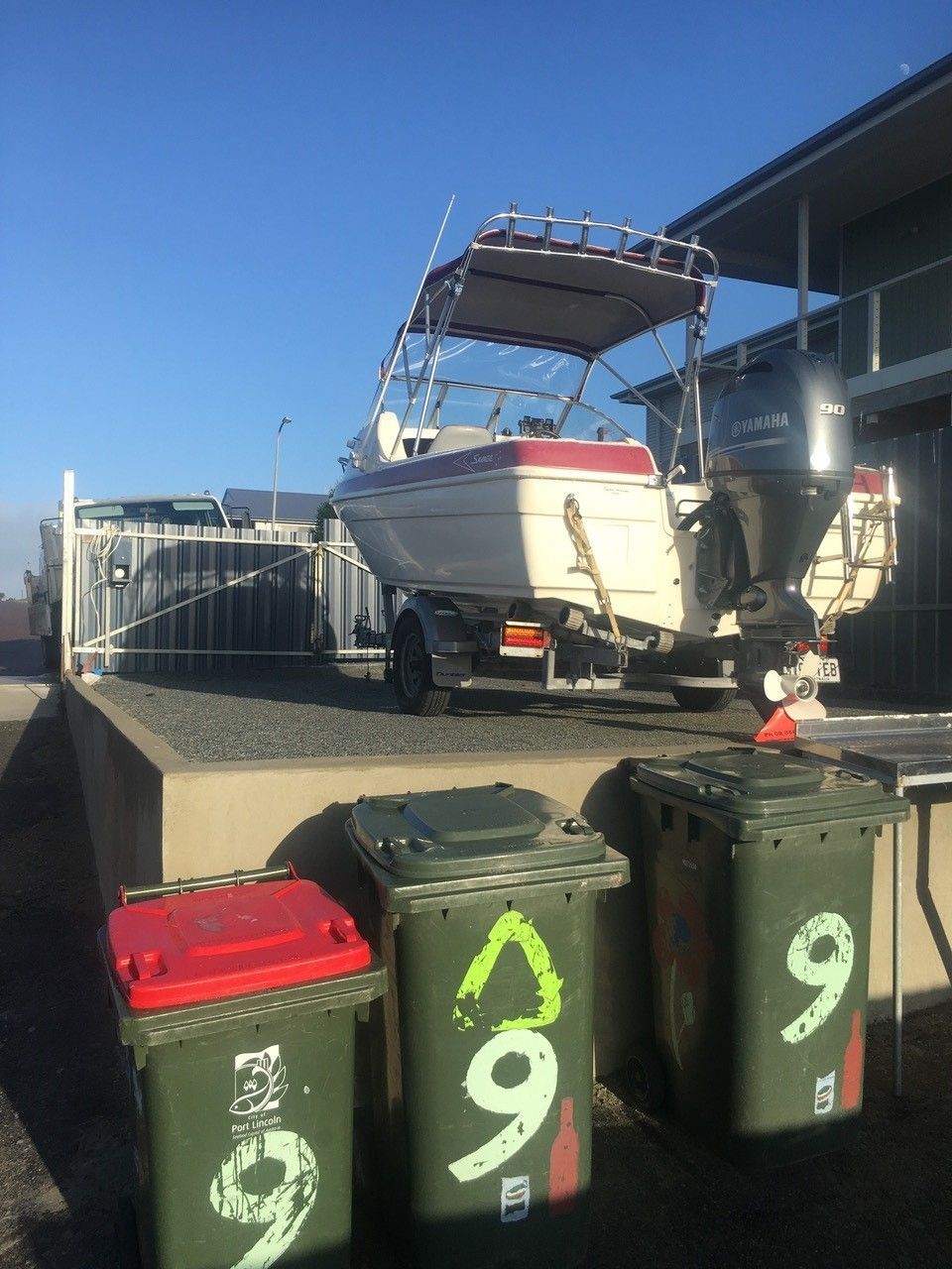 A boat is parked next to a row of garbage cans with the number 9 on them