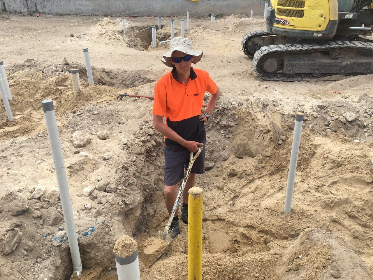 A man is digging in the dirt with a shovel.
