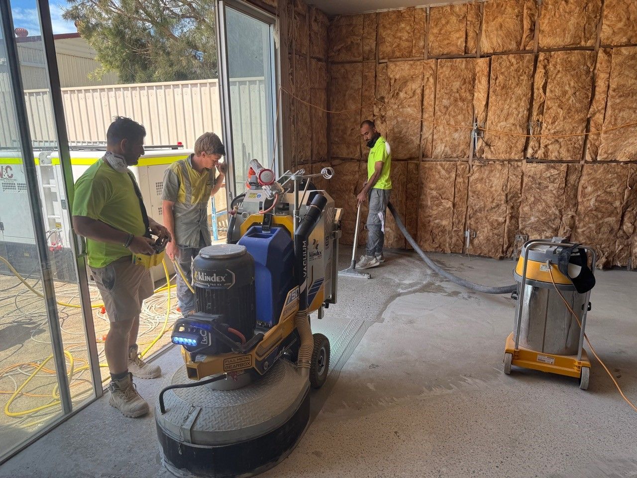 A group of men are standing around a machine in a room.