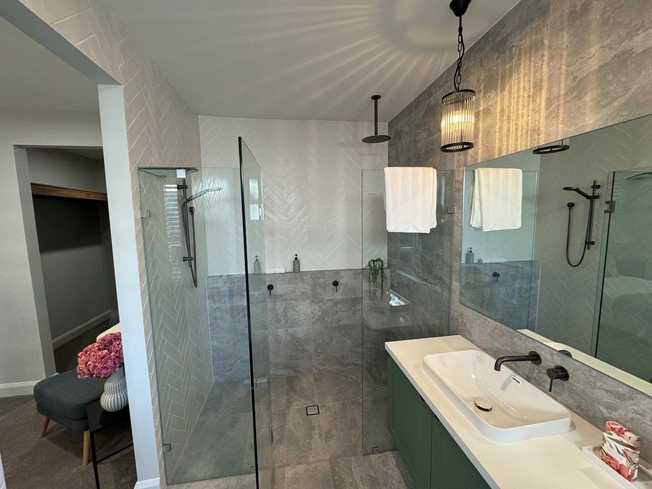 A bathroom with a sink and a walk in shower.