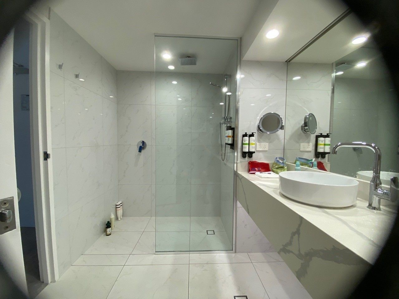 A bathroom with a sink , mirror and walk in shower.
