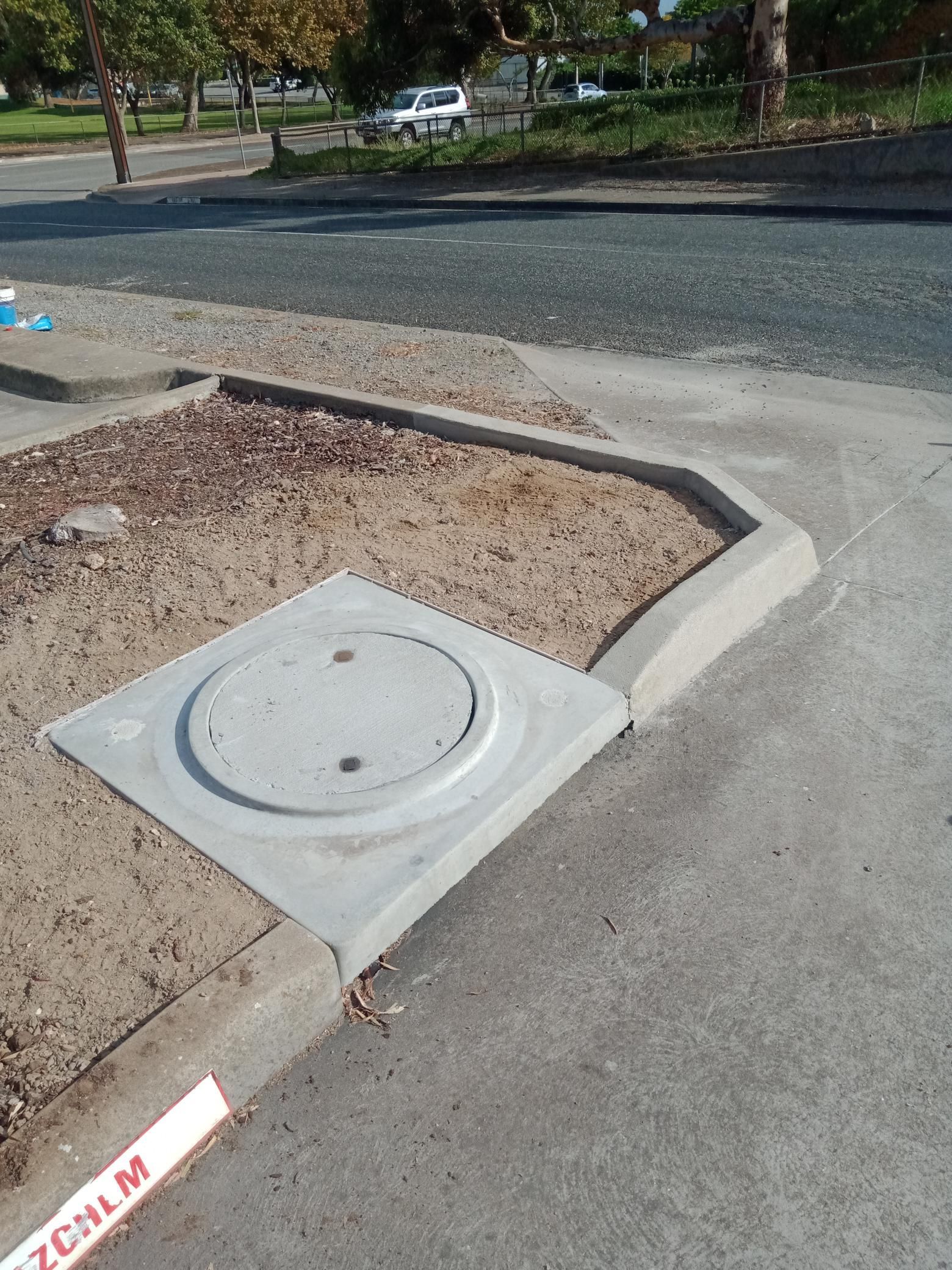 A manhole cover is sitting on the side of the road.