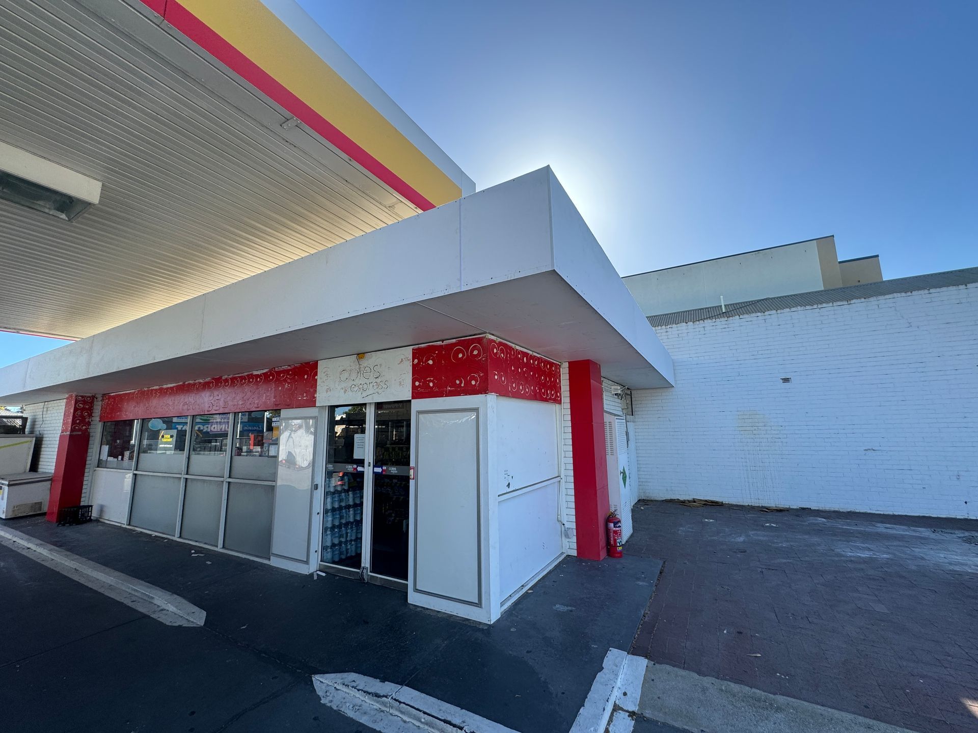 A gas station with a red and yellow striped roof