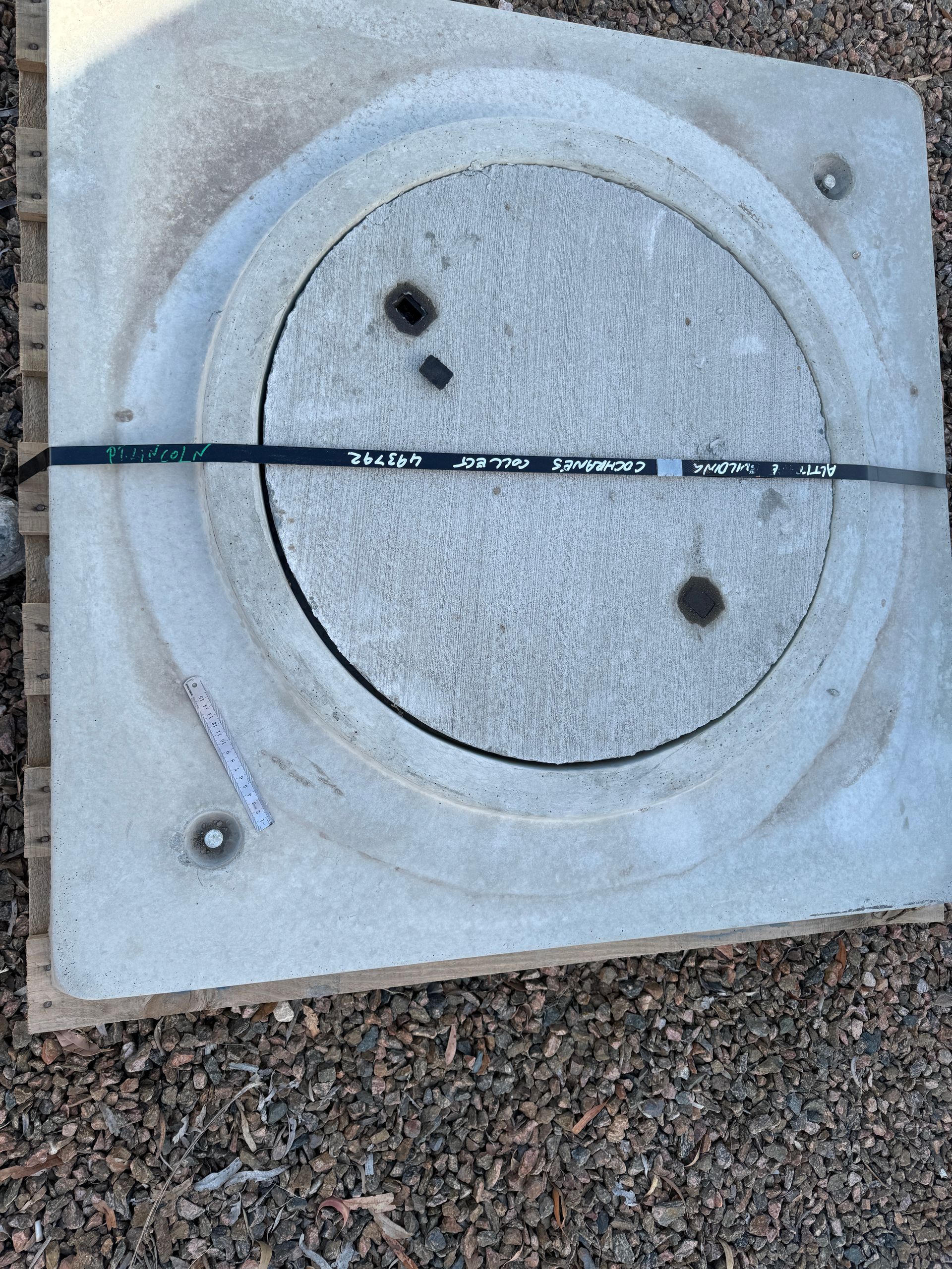 A manhole cover is sitting on top of a pile of gravel.