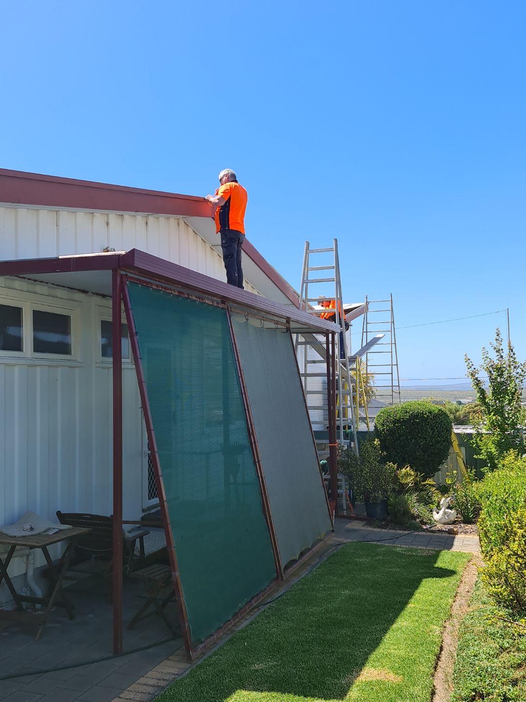 Two men are working on the roof of a house.
