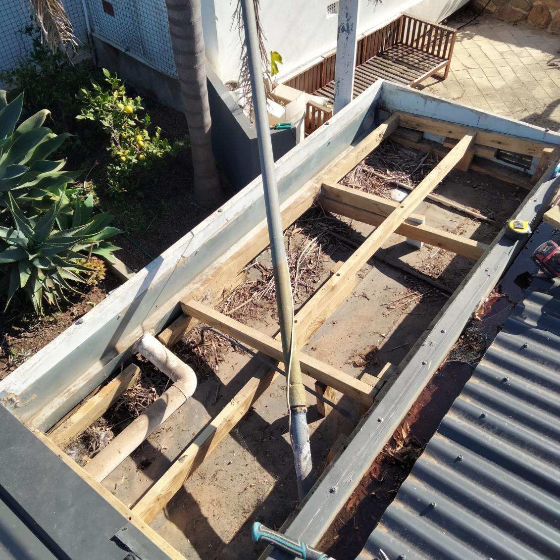 A wooden structure is being built on top of a roof