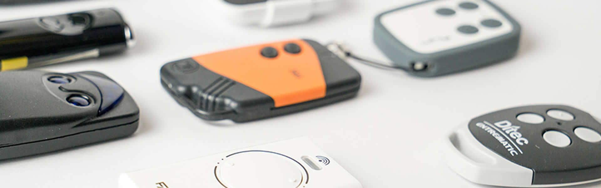 Su una semplice superficie bianca sono sparsi vari apriporta per garage e telecomandi.