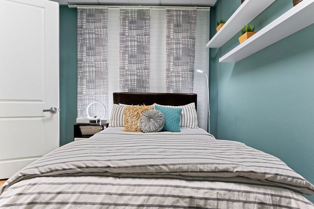 A bedroom with a bed , shelves and a window. | United Critical Care