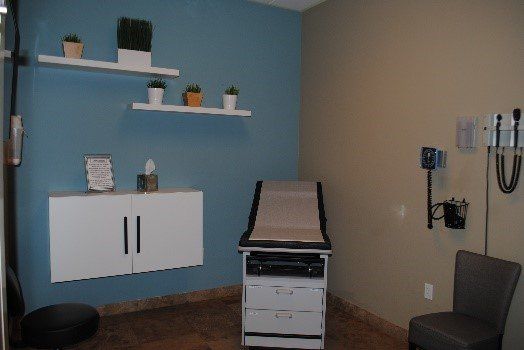 A doctor 's office with a chair and a desk | United Critical Care