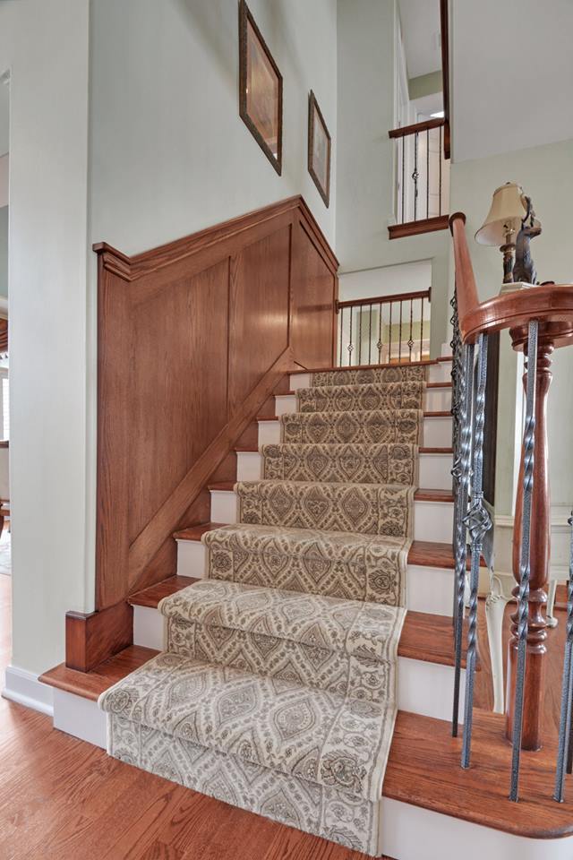 a wooden staircase with a rug on the steps in a house .