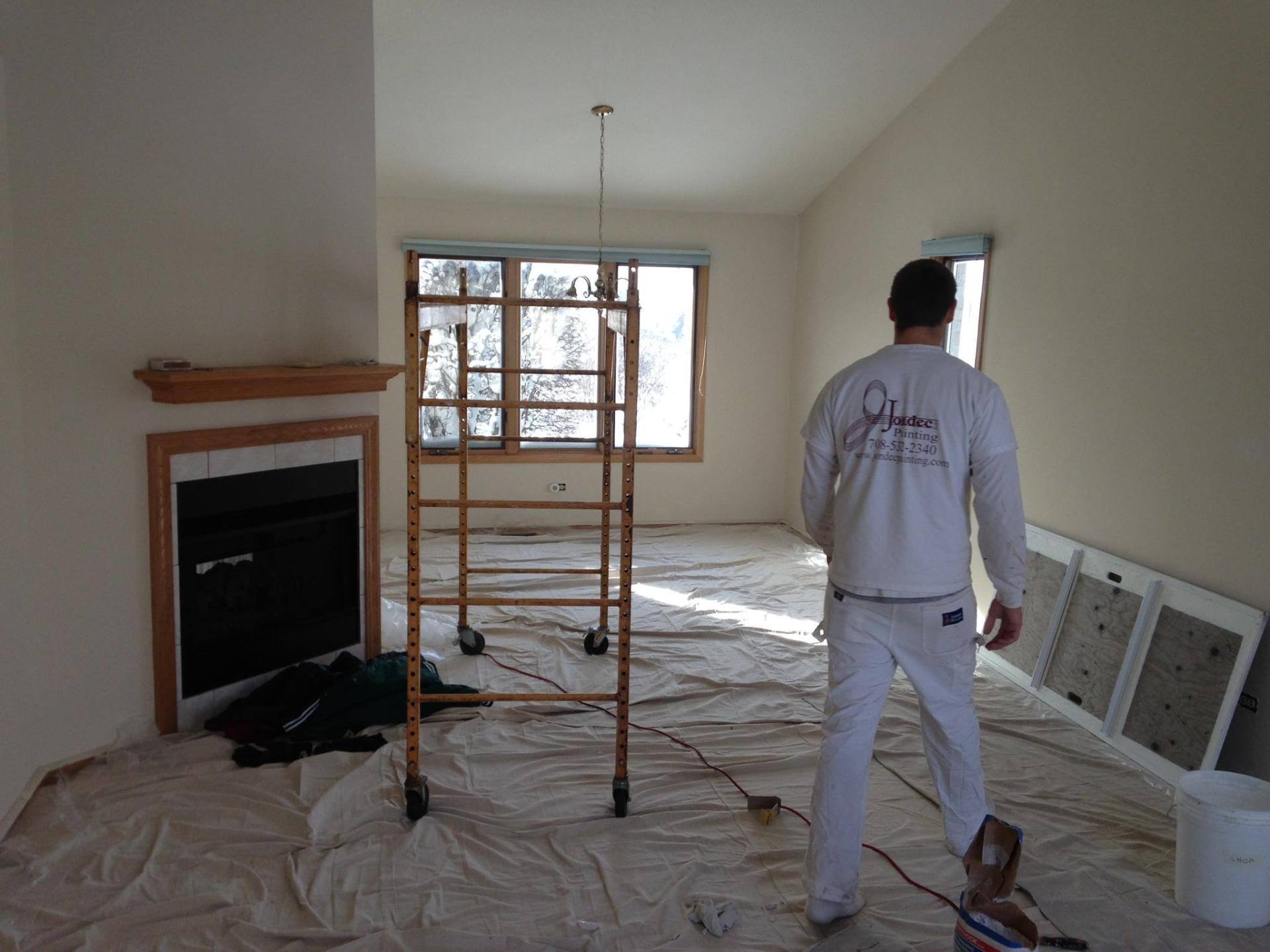 a man is standing in a living room with a ladder in the background .