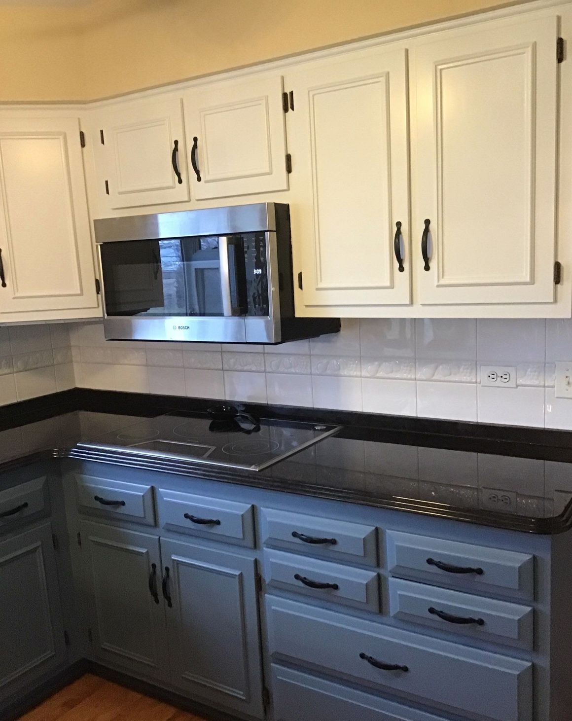 a kitchen with white cabinets and a stainless steel microwave oven .