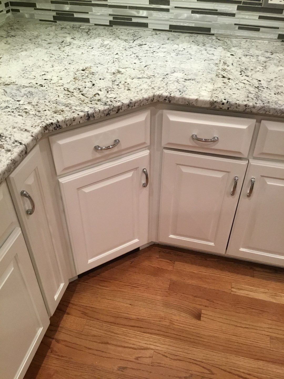 a kitchen with white cabinets and granite counter tops .