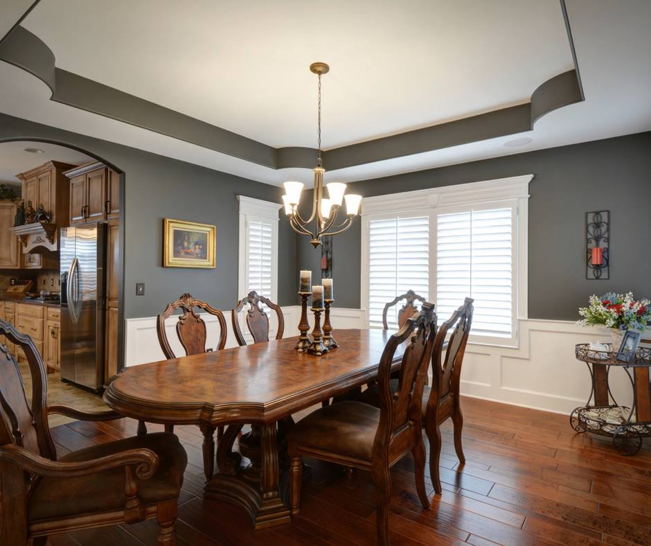 a dining room with a wooden table and chairs and a chandelier .