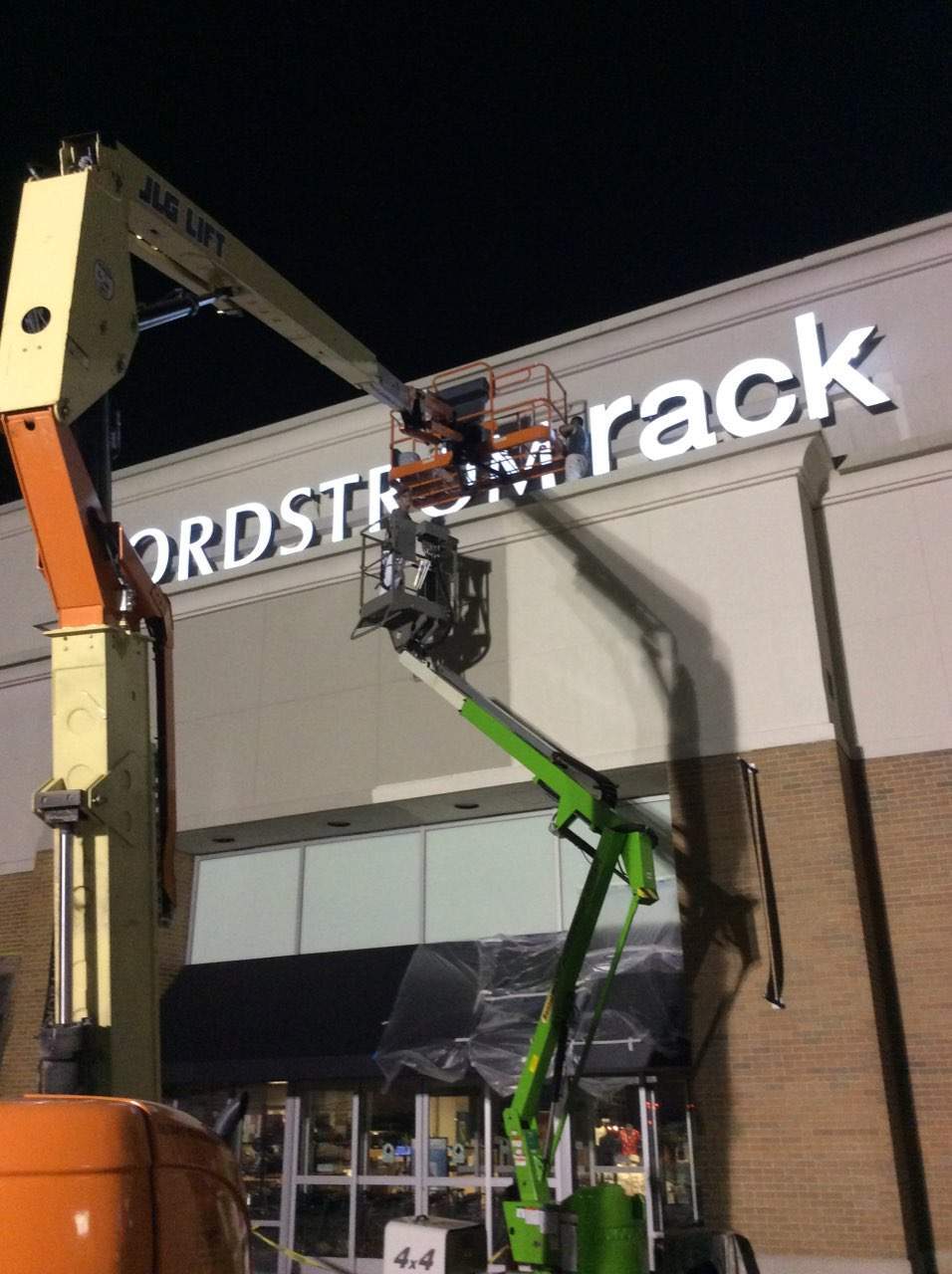 a crane is lifting a sign that says nordstrom rack