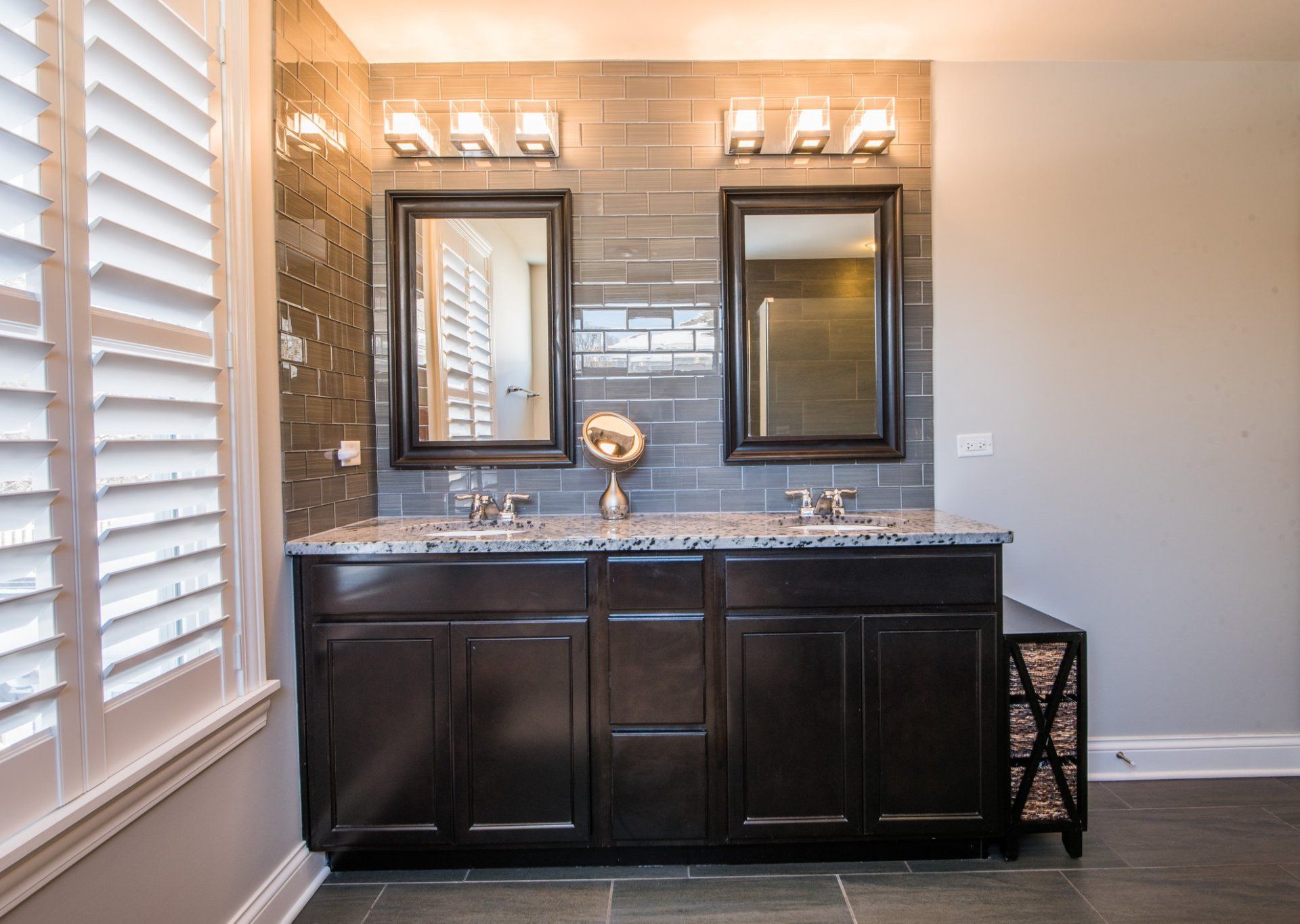 a bathroom with two sinks and two mirrors .