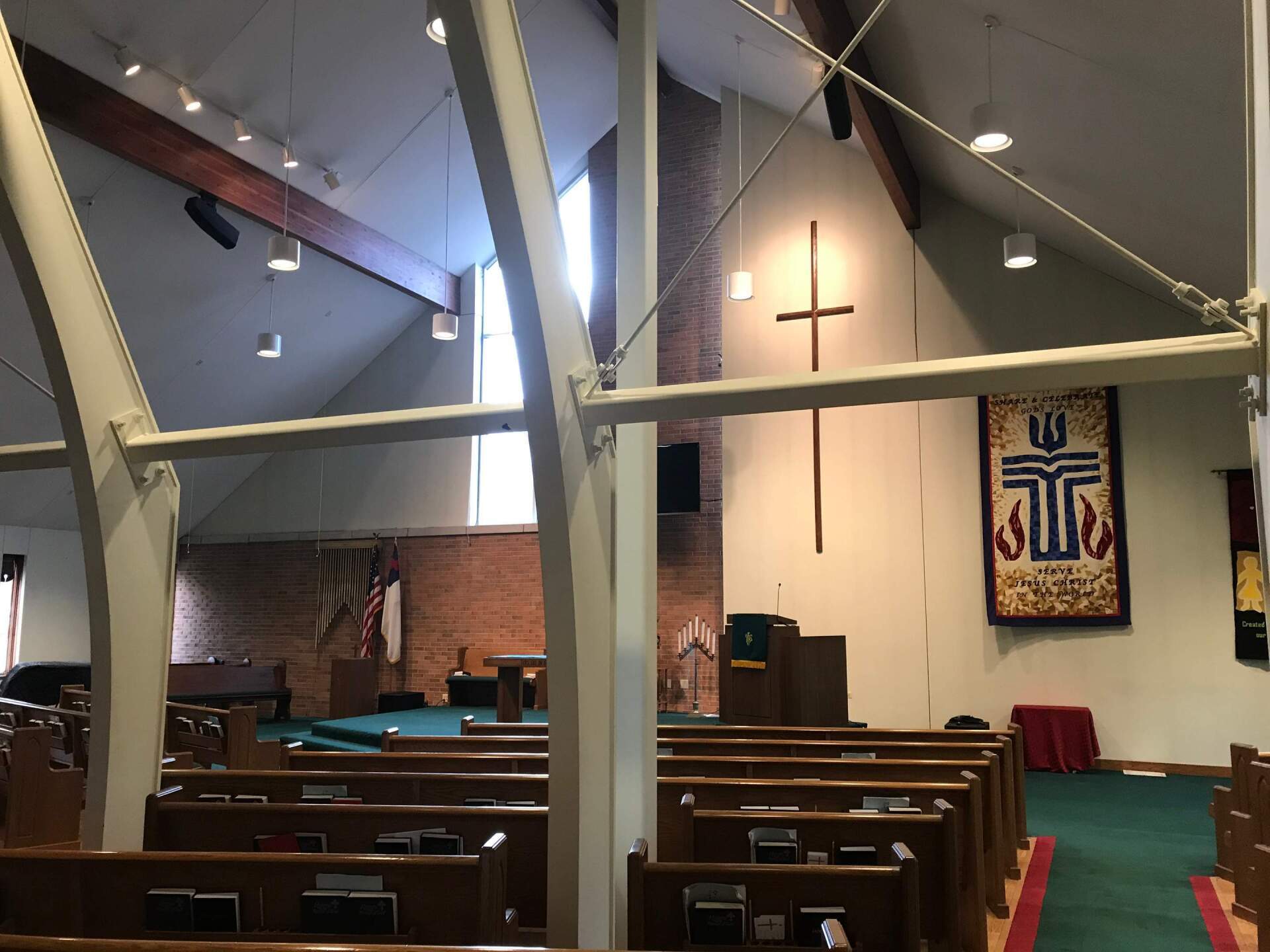 the inside of a church with a cross on the wall