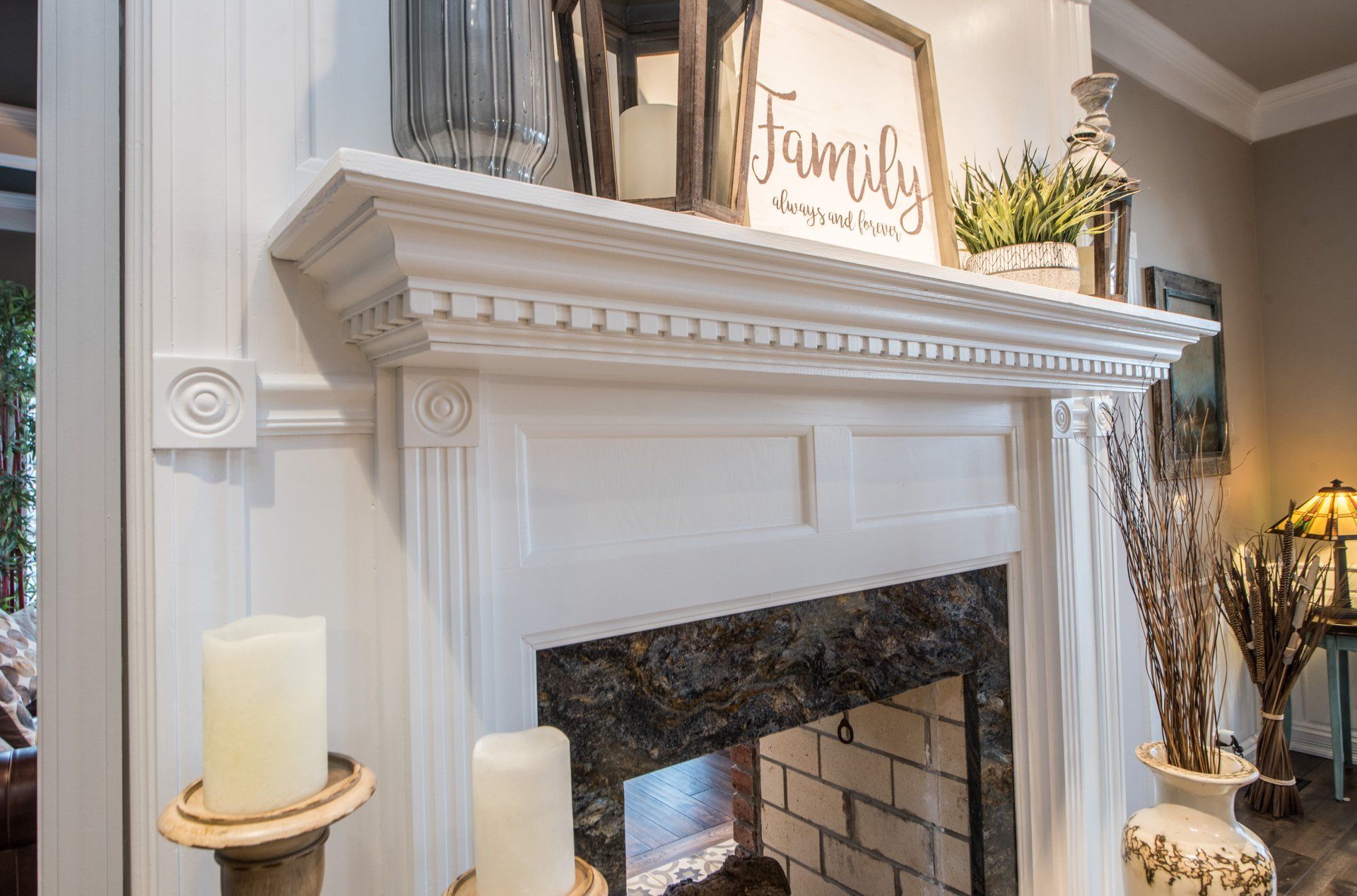 a fireplace with a mantle and candles in a living room .
