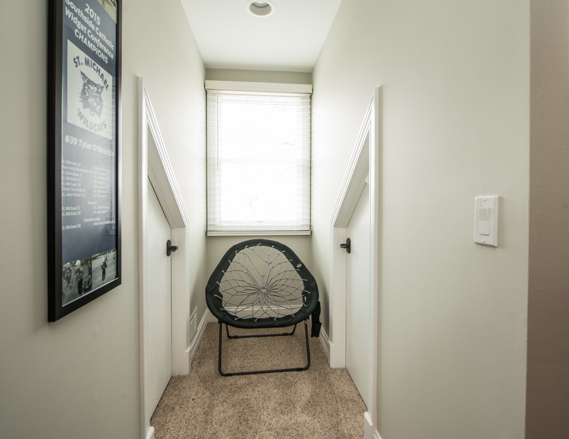 a hallway with a chair and a picture on the wall .