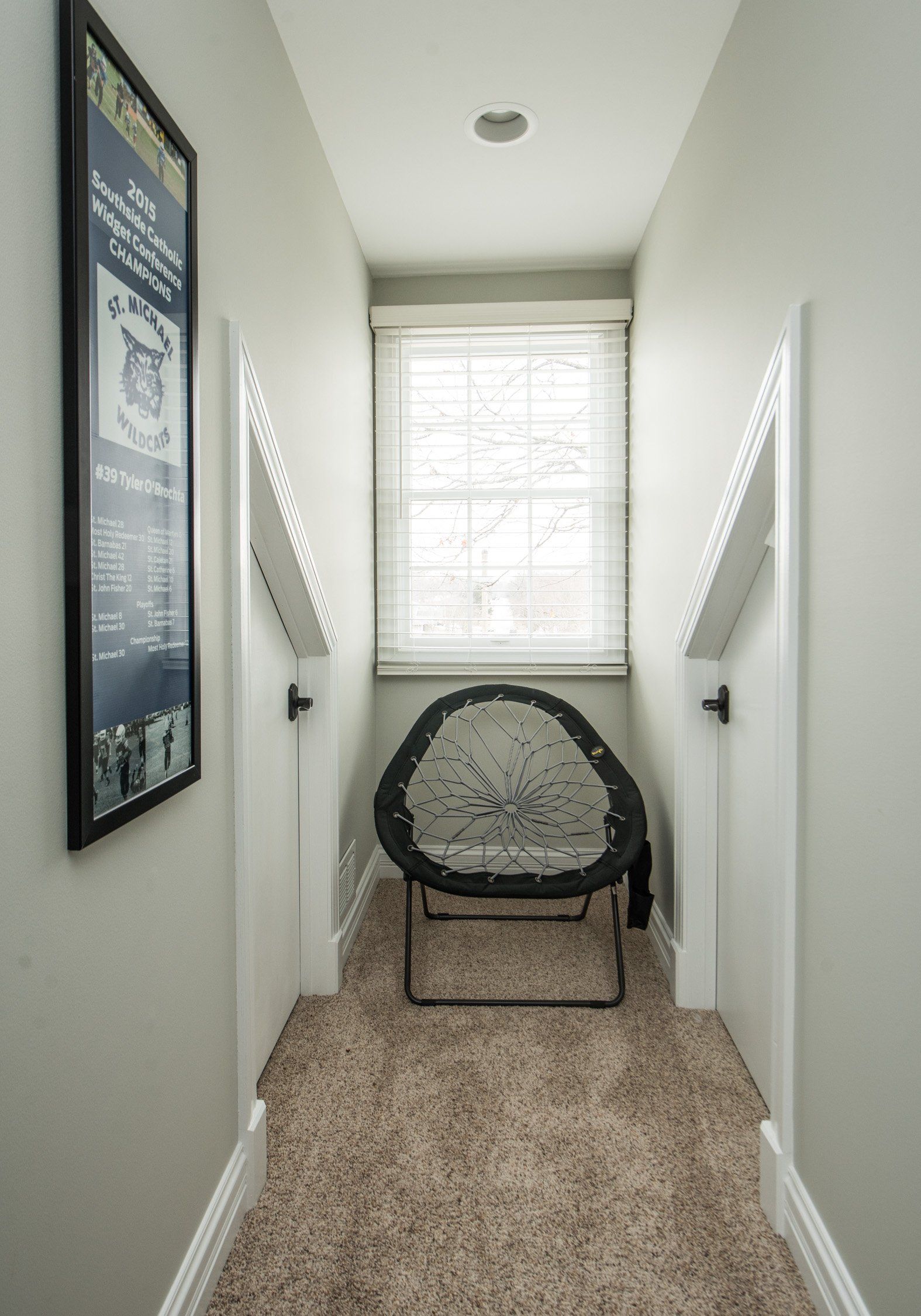 a long hallway with a chair and a window .