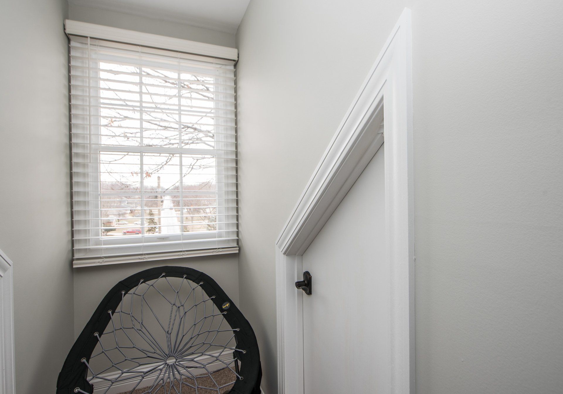 there is a chair in the corner of the room next to a window .