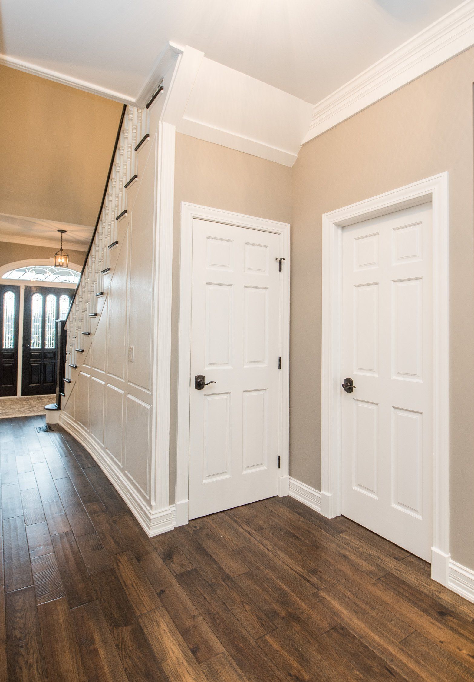 a hallway with hardwood floors and white doors in a house .