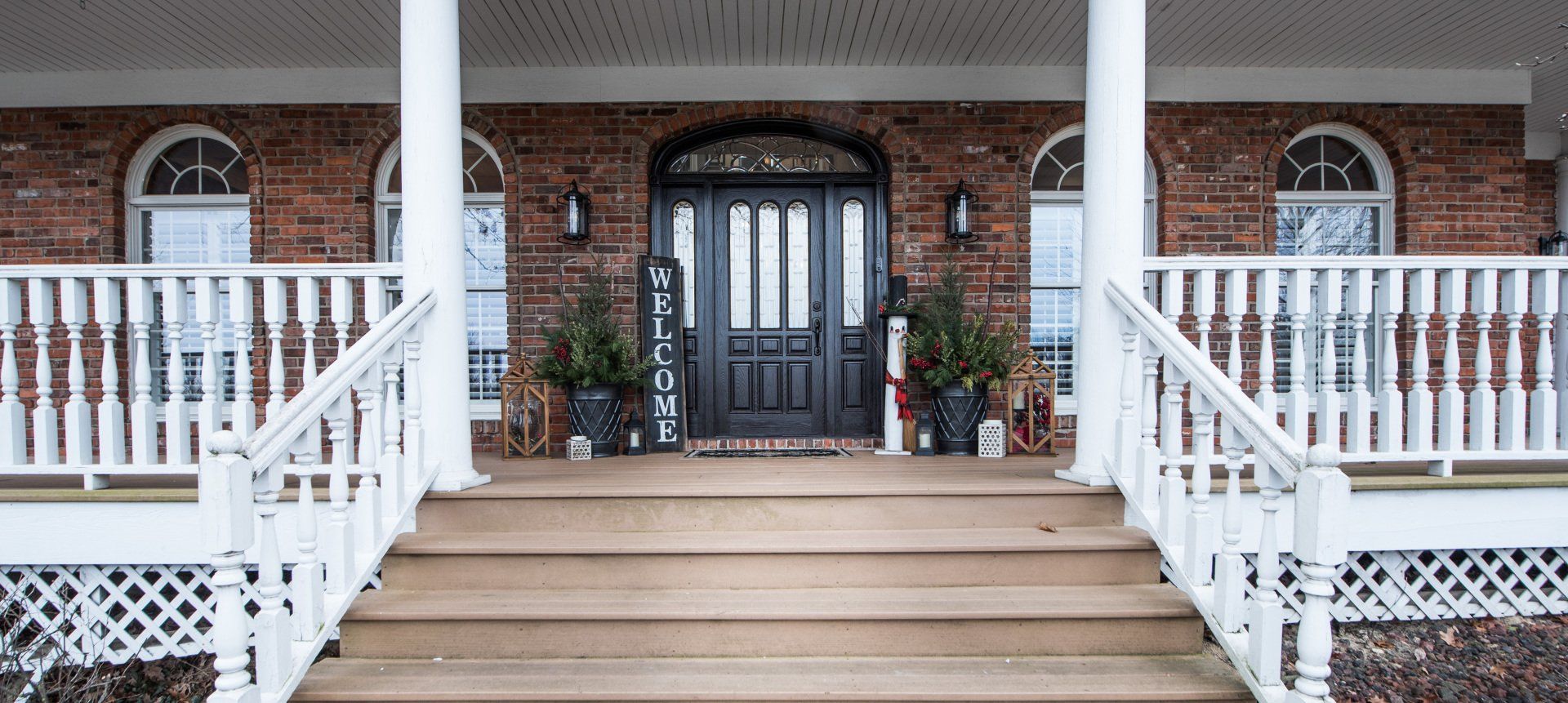 a brick house with a porch and stairs leading to the front door .