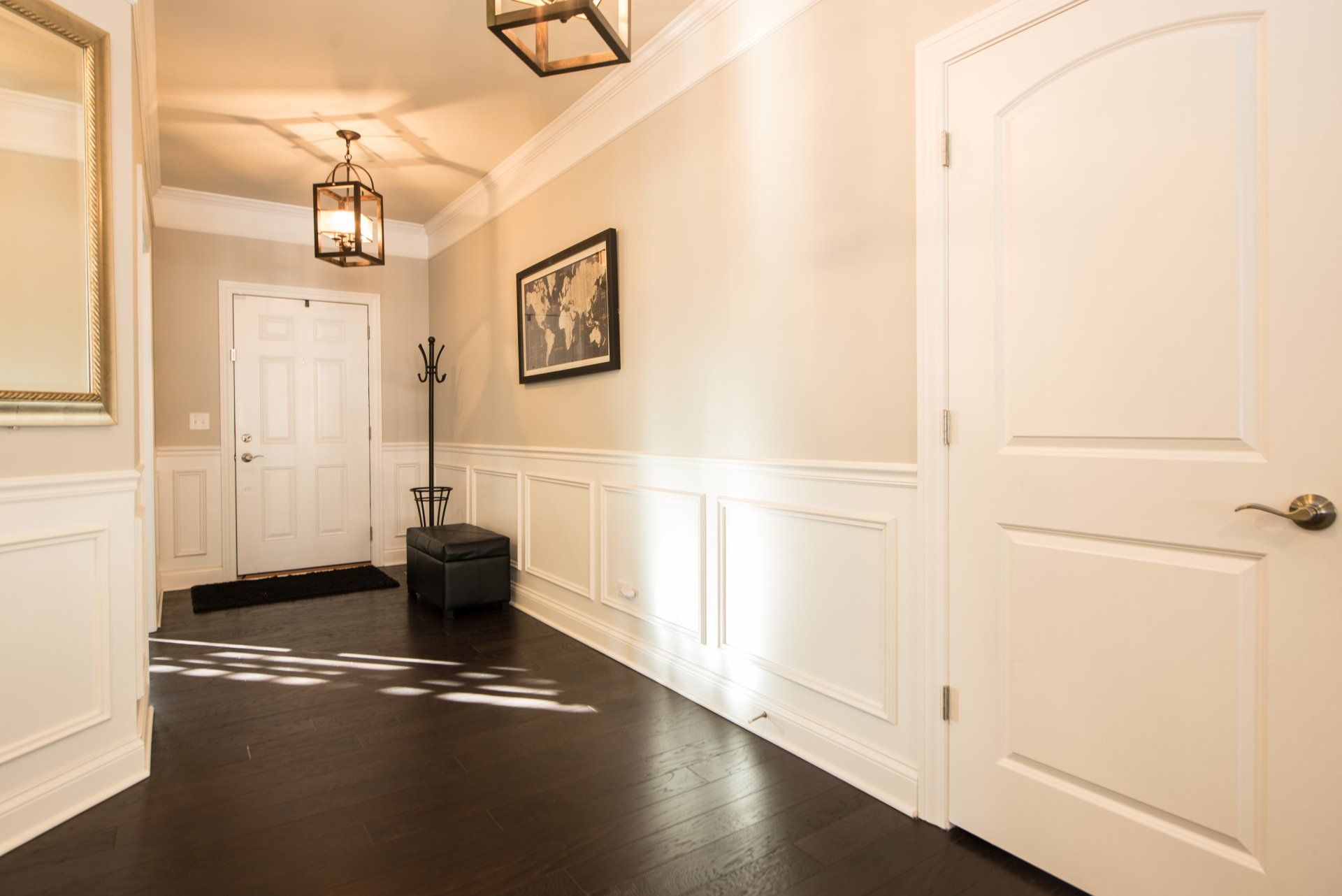 a hallway with white trim and a picture on the wall .