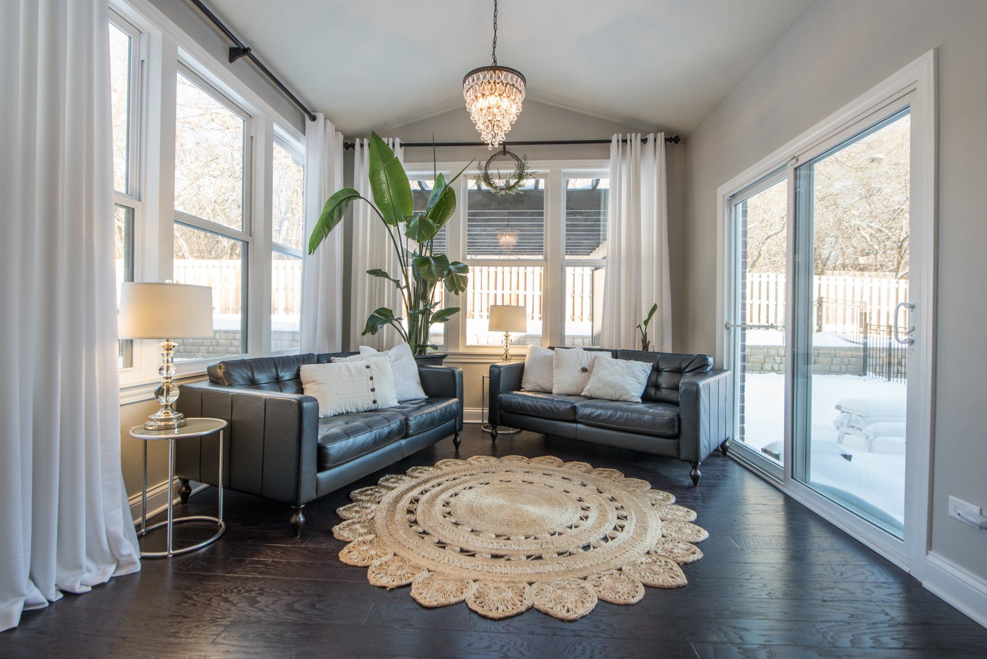 a living room with two couches , a rug , and a chandelier .