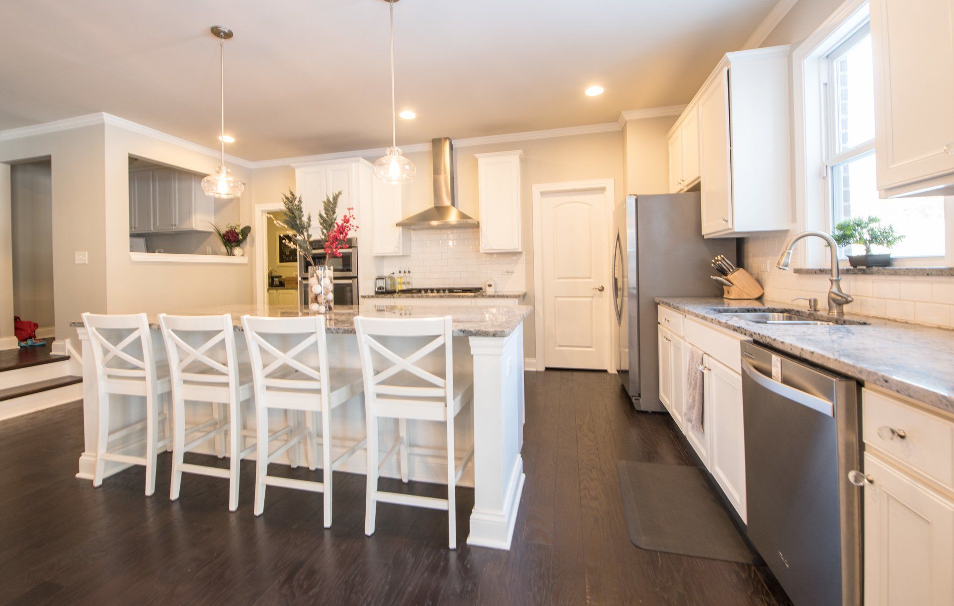 a kitchen with white cabinets , stainless steel appliances , and a large island .