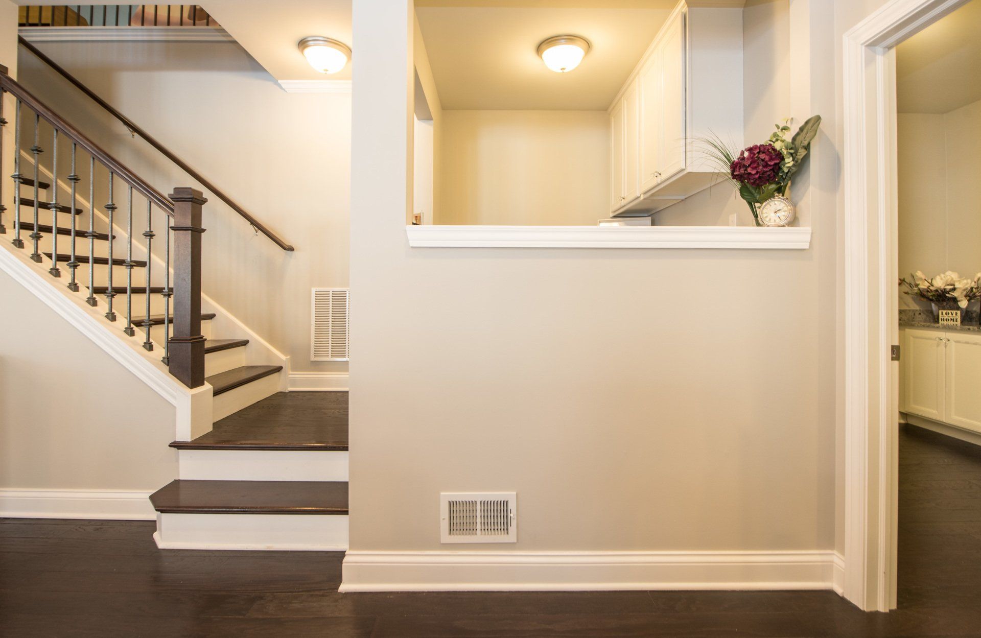 a hallway with stairs leading up to a kitchen .