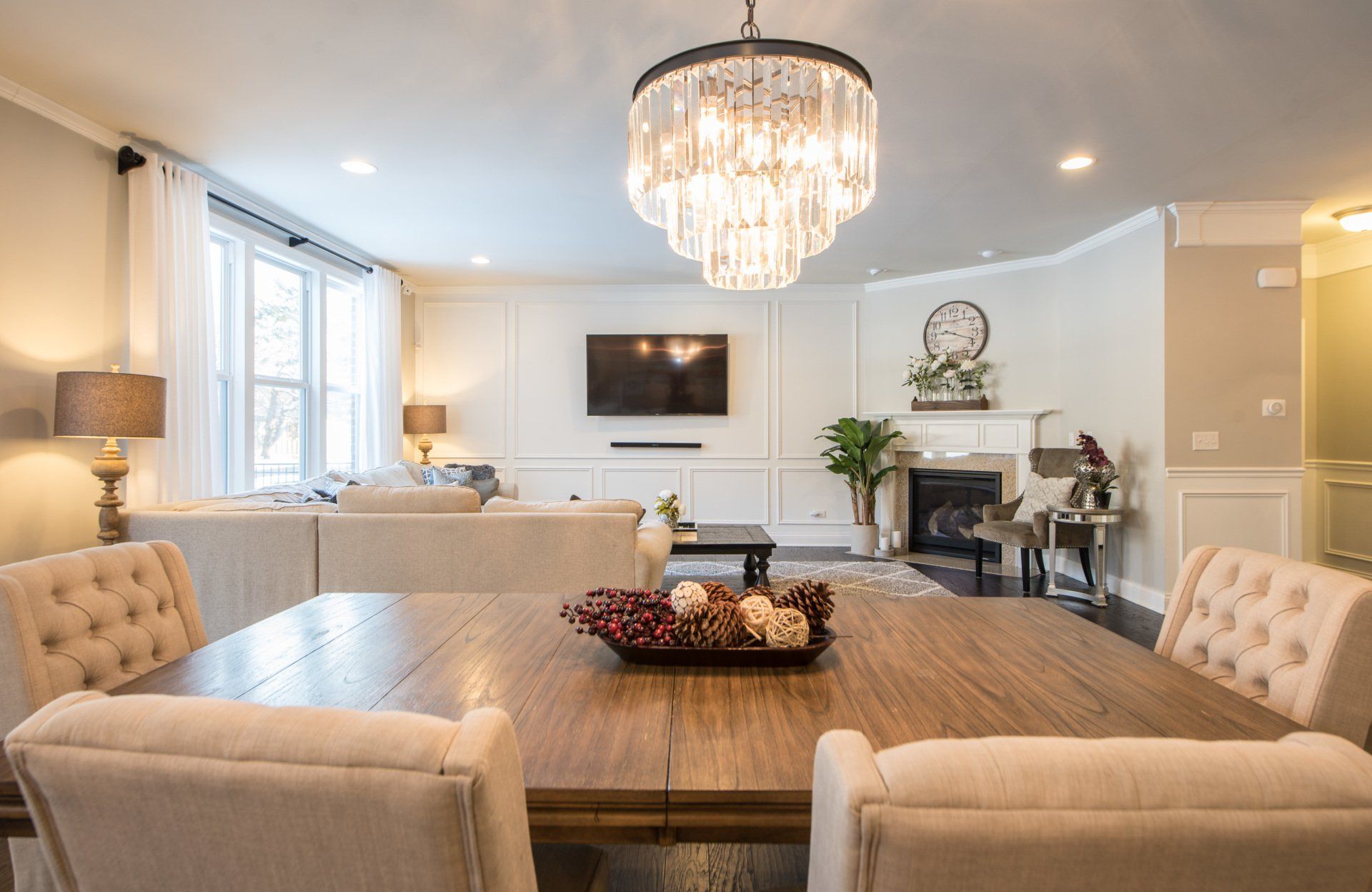 a living room with a dining table and chairs and a chandelier .