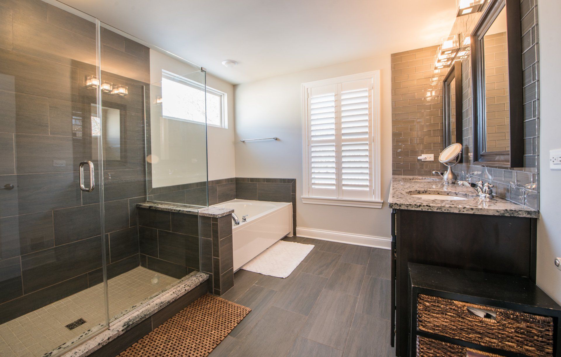 a bathroom with a walk in shower , tub , sink and mirror .