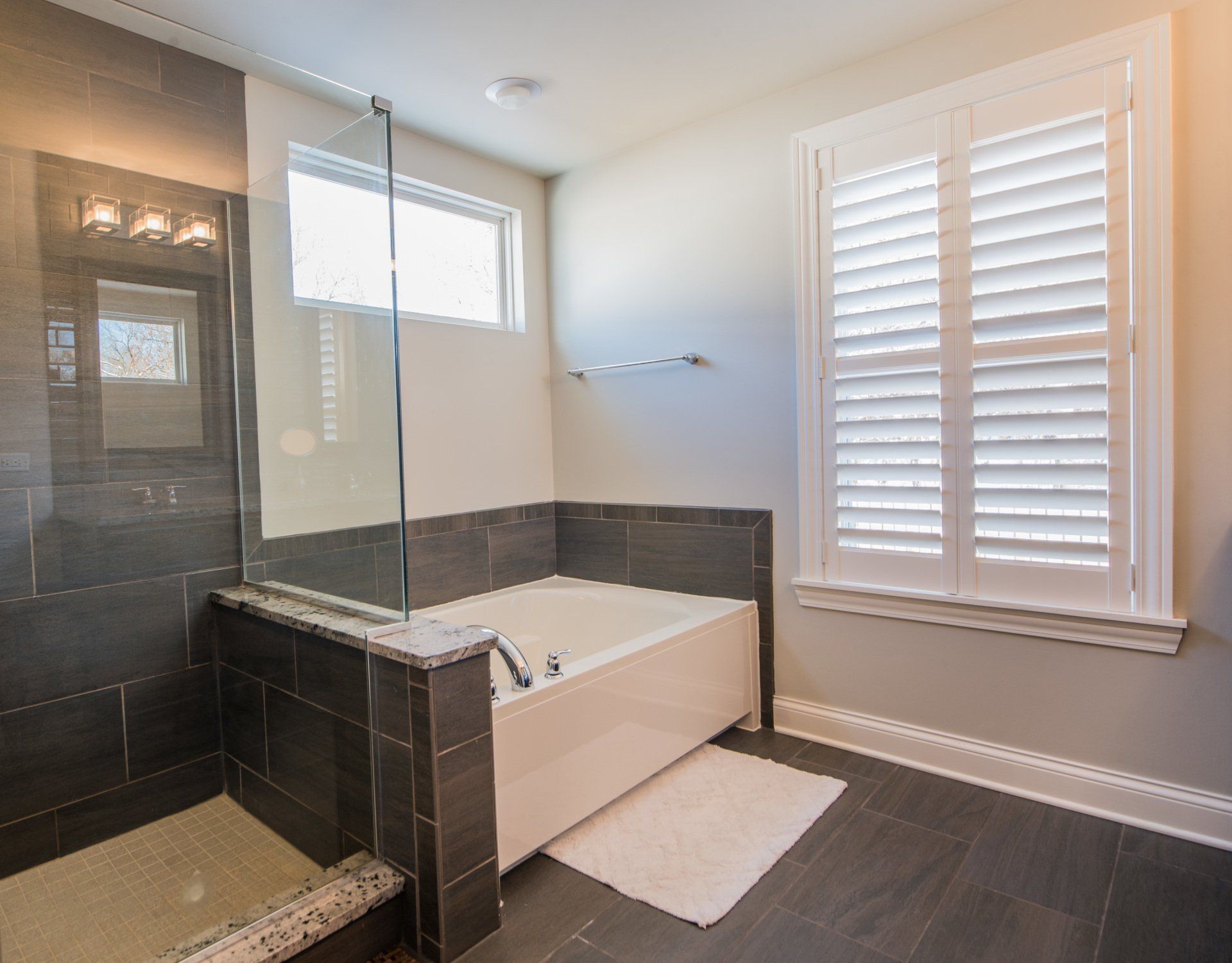 a bathroom with a tub , shower and window .