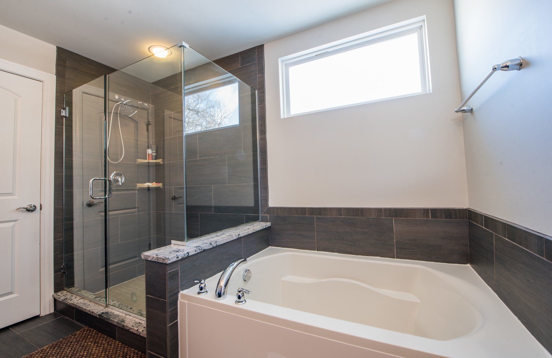 a bathroom with a tub , shower , and window .