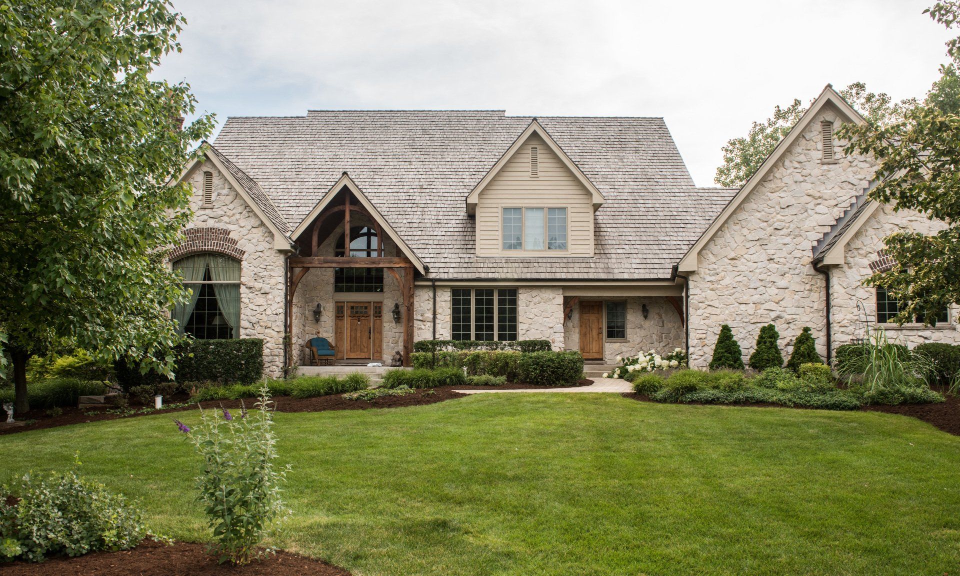 a large brick house with a lush green lawn in front of it .