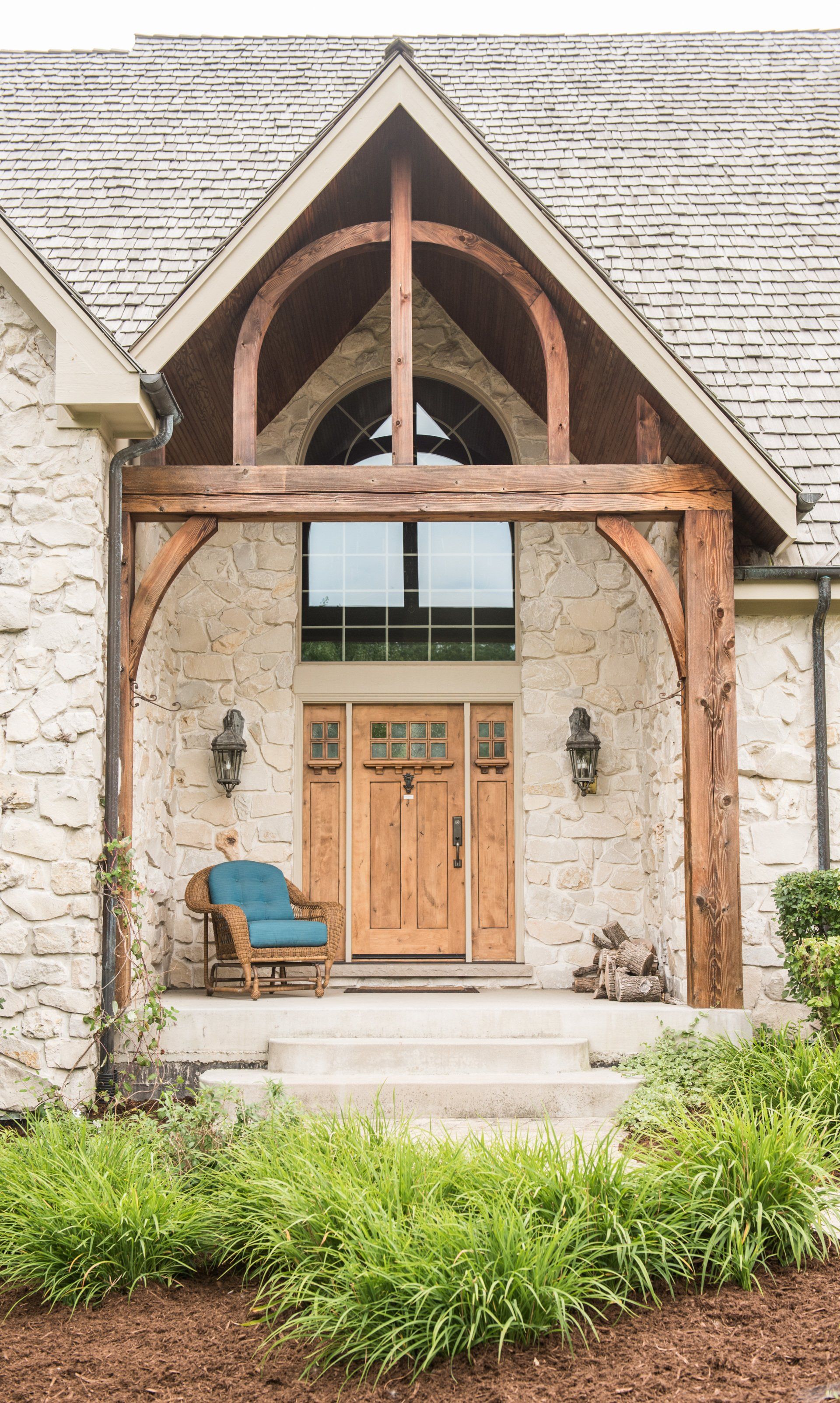 a large stone house with a wooden porch and a wooden door .