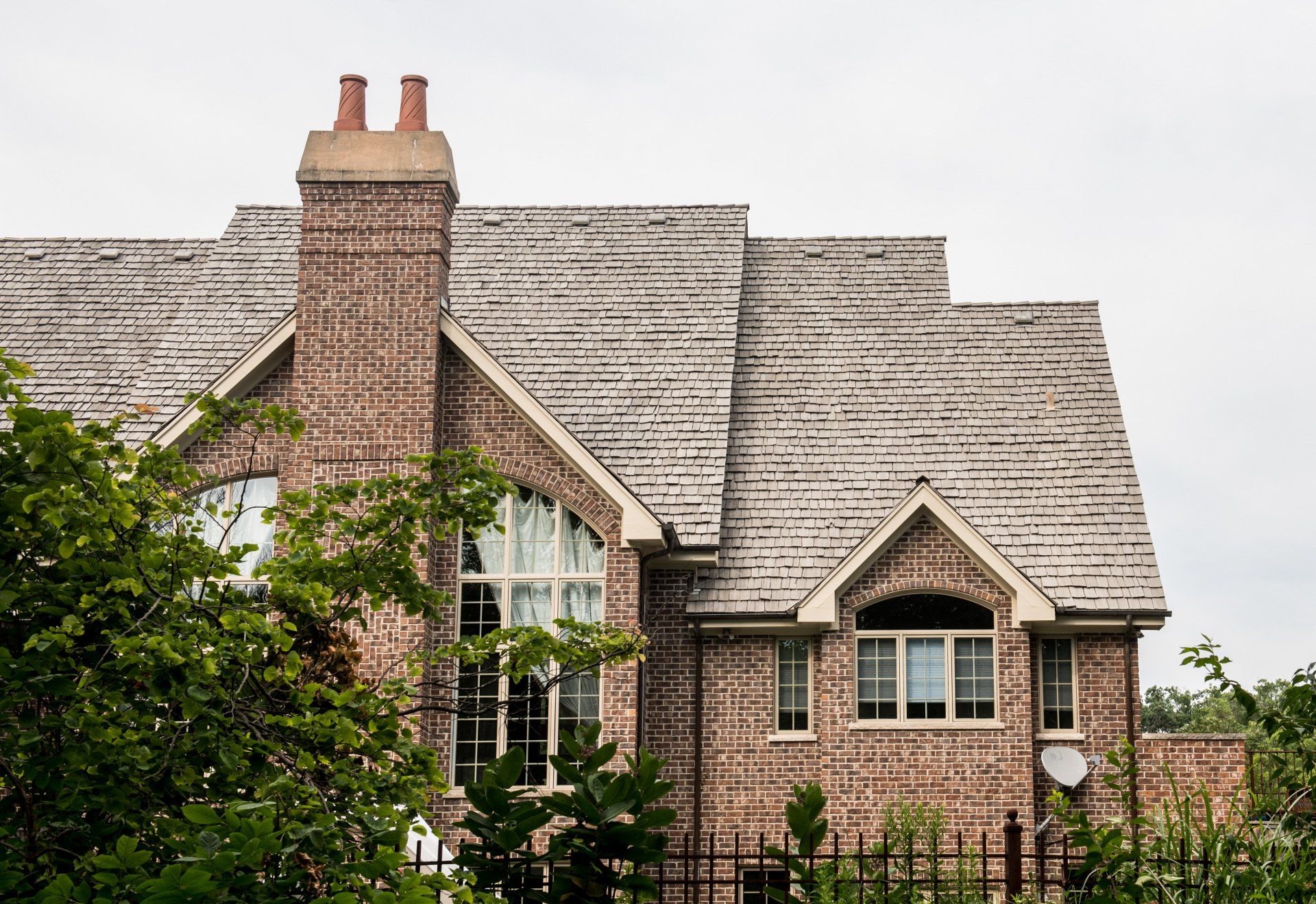 a large brick house with a chimney on the roof