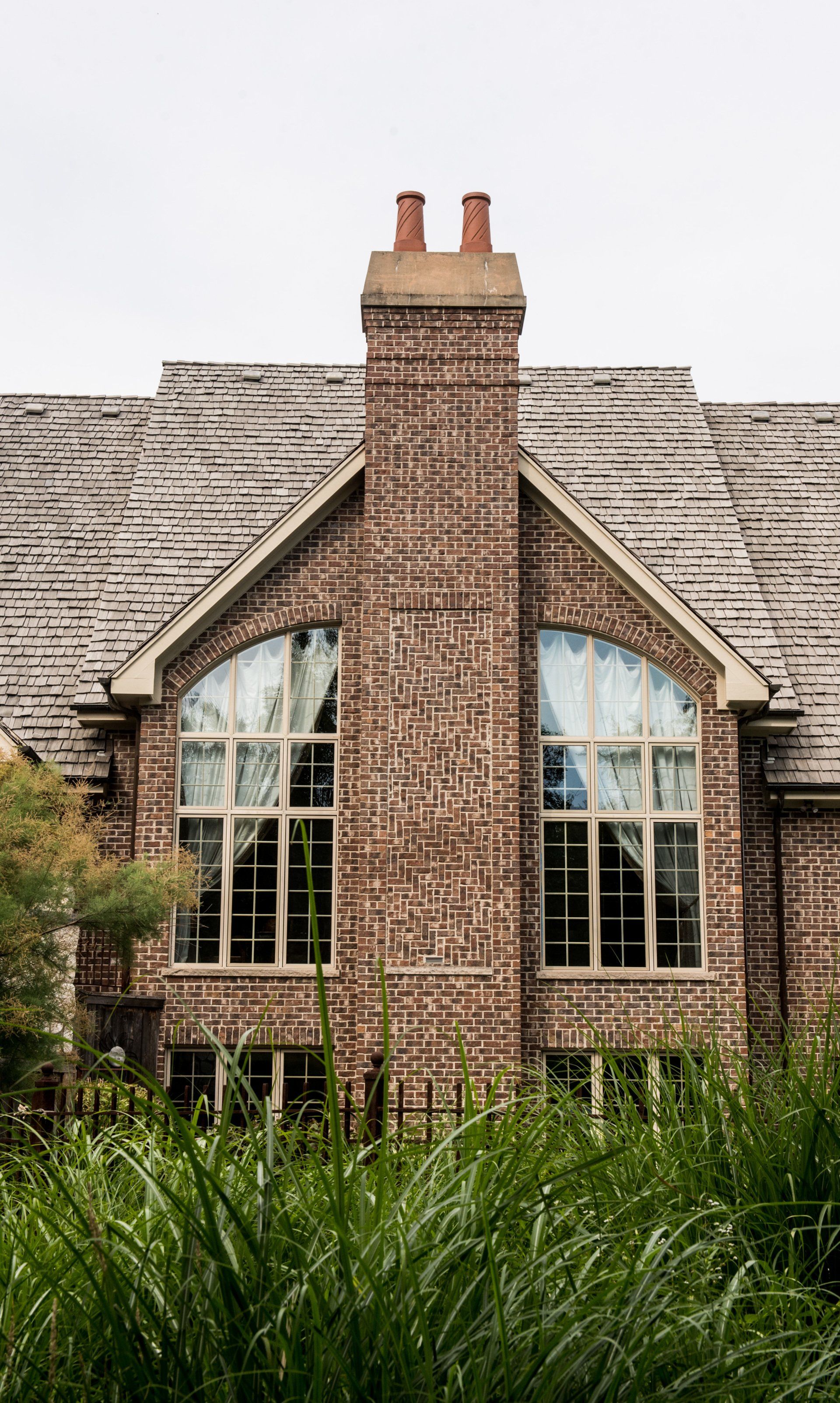 a large brick house with arched windows and a chimney .