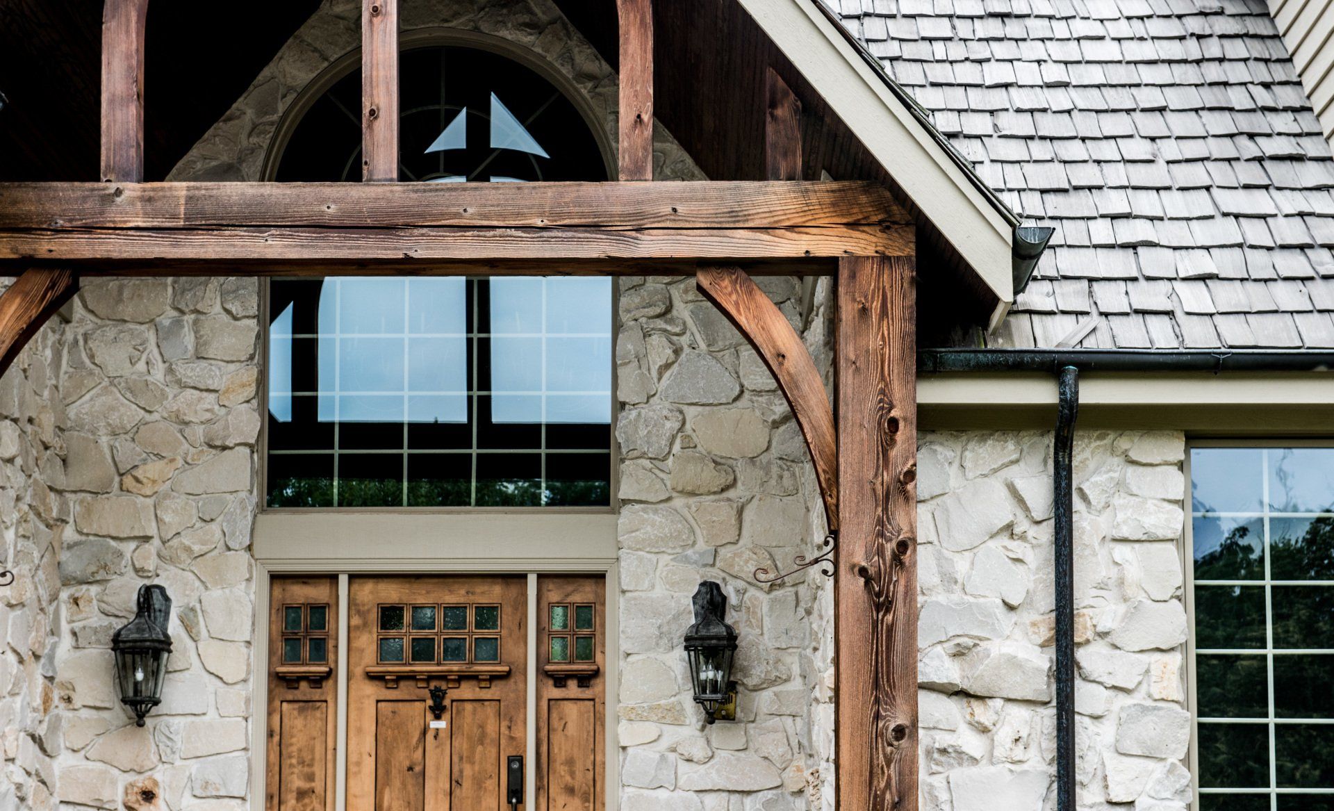 a large stone house with a wooden porch and a wooden door .