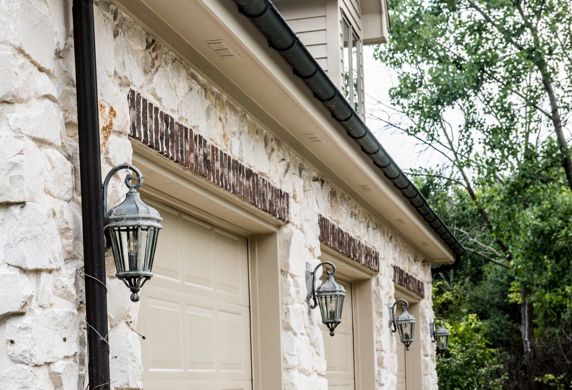 a stone building with three garage doors and a gutter .