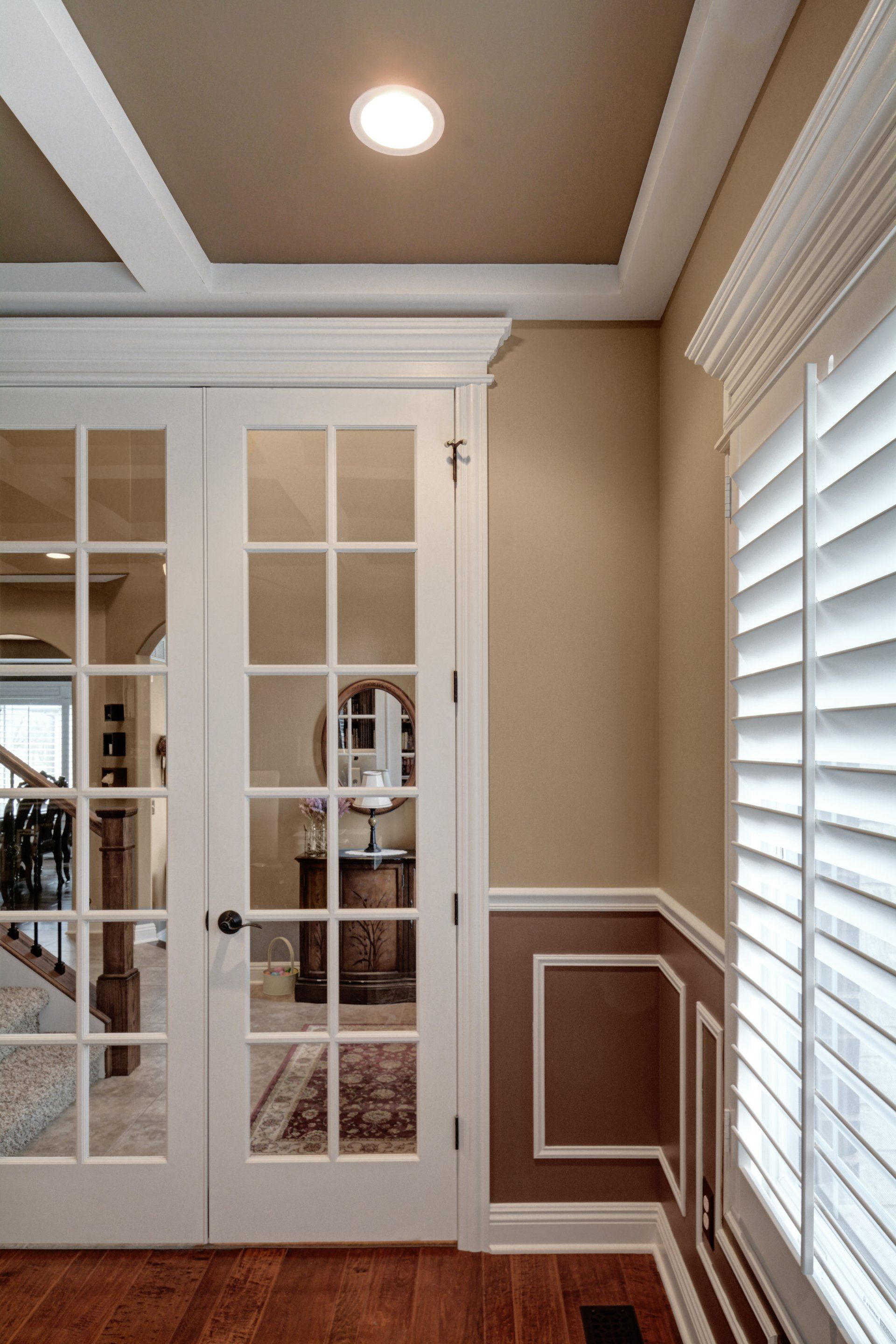 a room with french doors and shutters on the windows