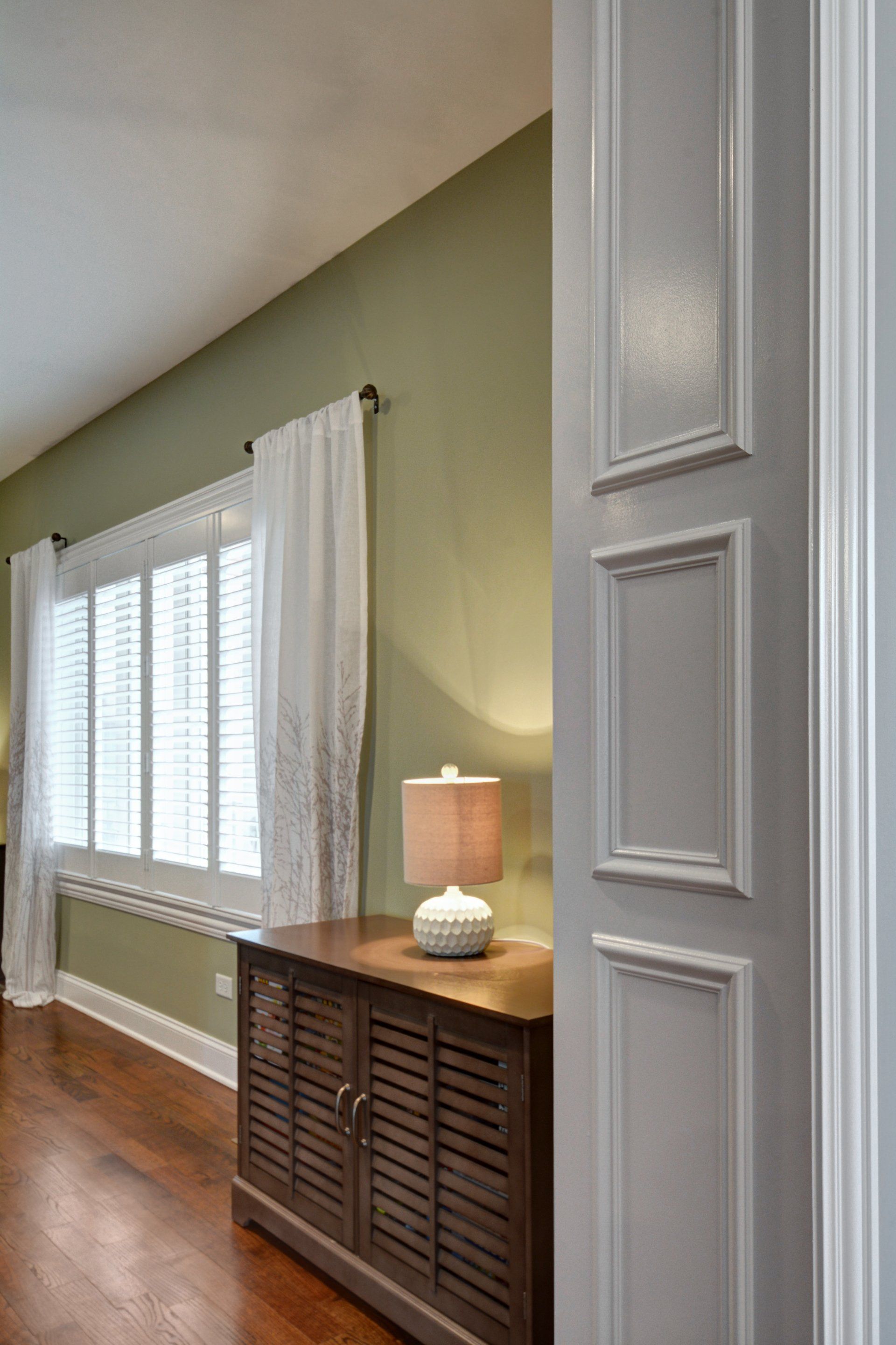 a room with a dresser and a lamp in it