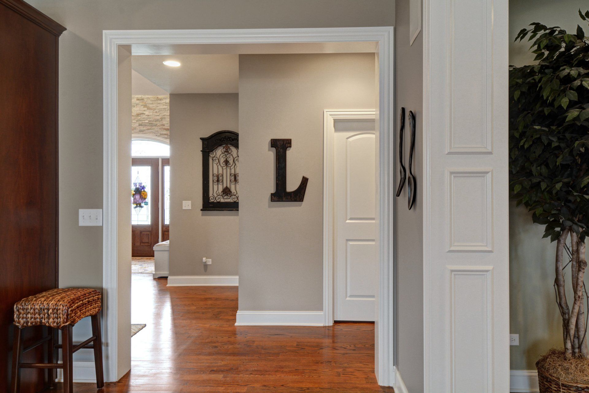 a hallway in a house with hardwood floors and a clock on the wall .