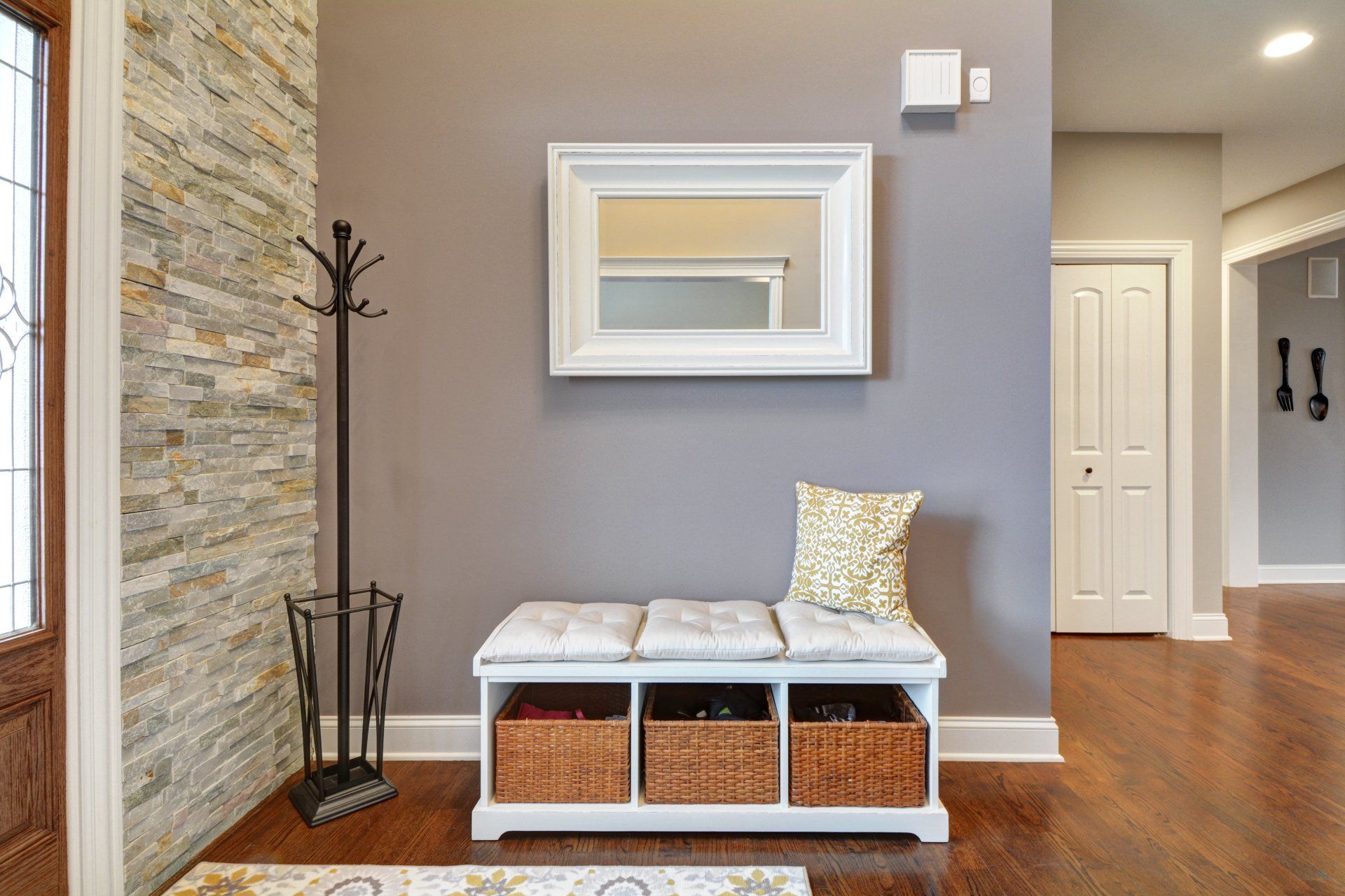 a hallway with a bench and a mirror on the wall .