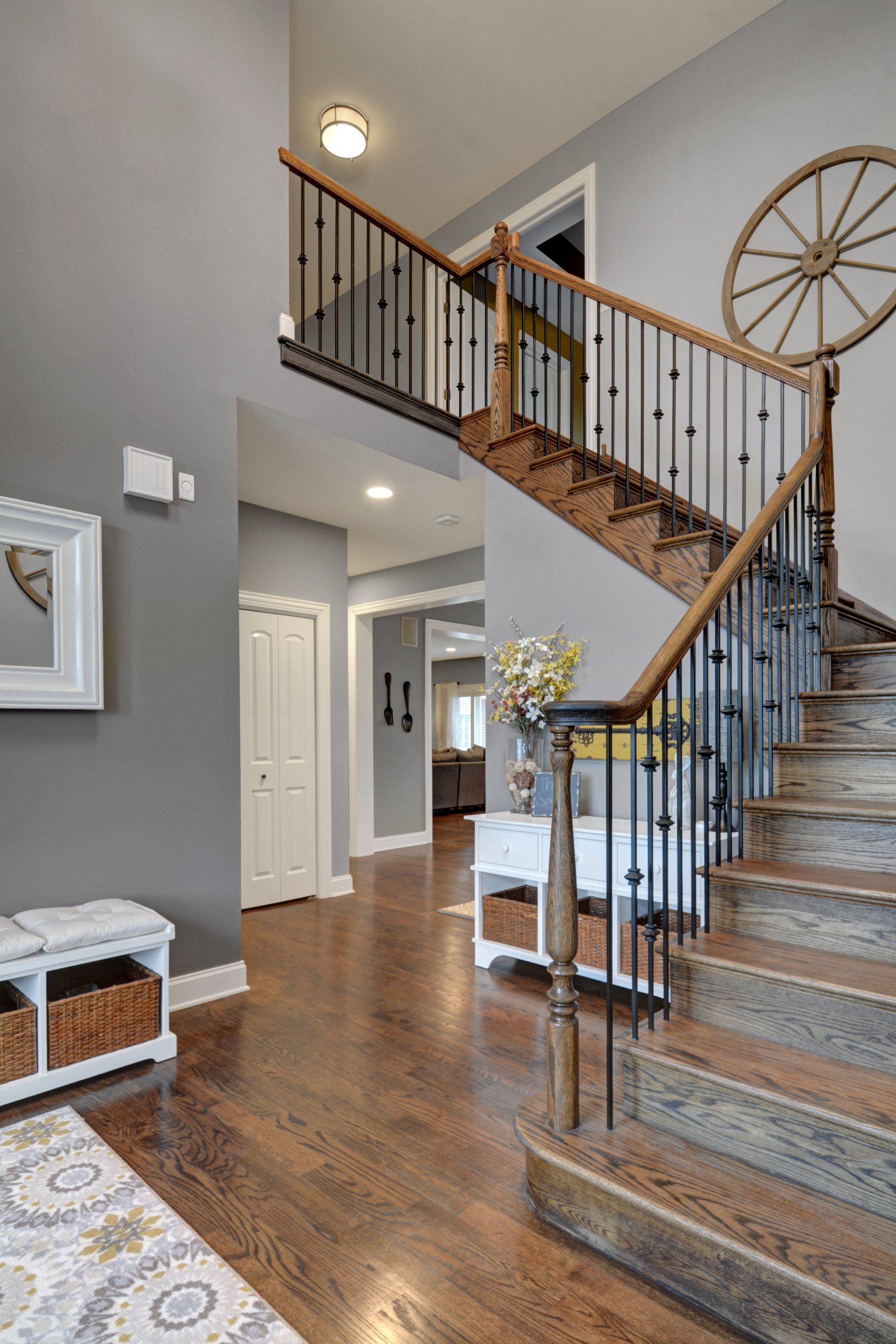 a staircase in a house with a wagon wheel on the railing .