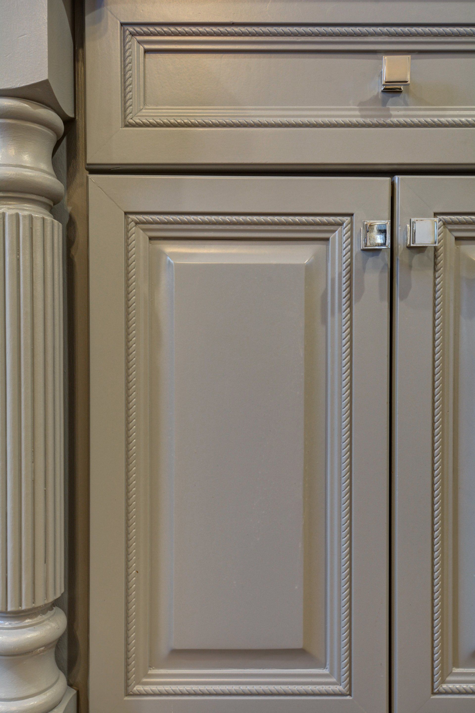 a close up of a gray cabinet with a pillar in the background .