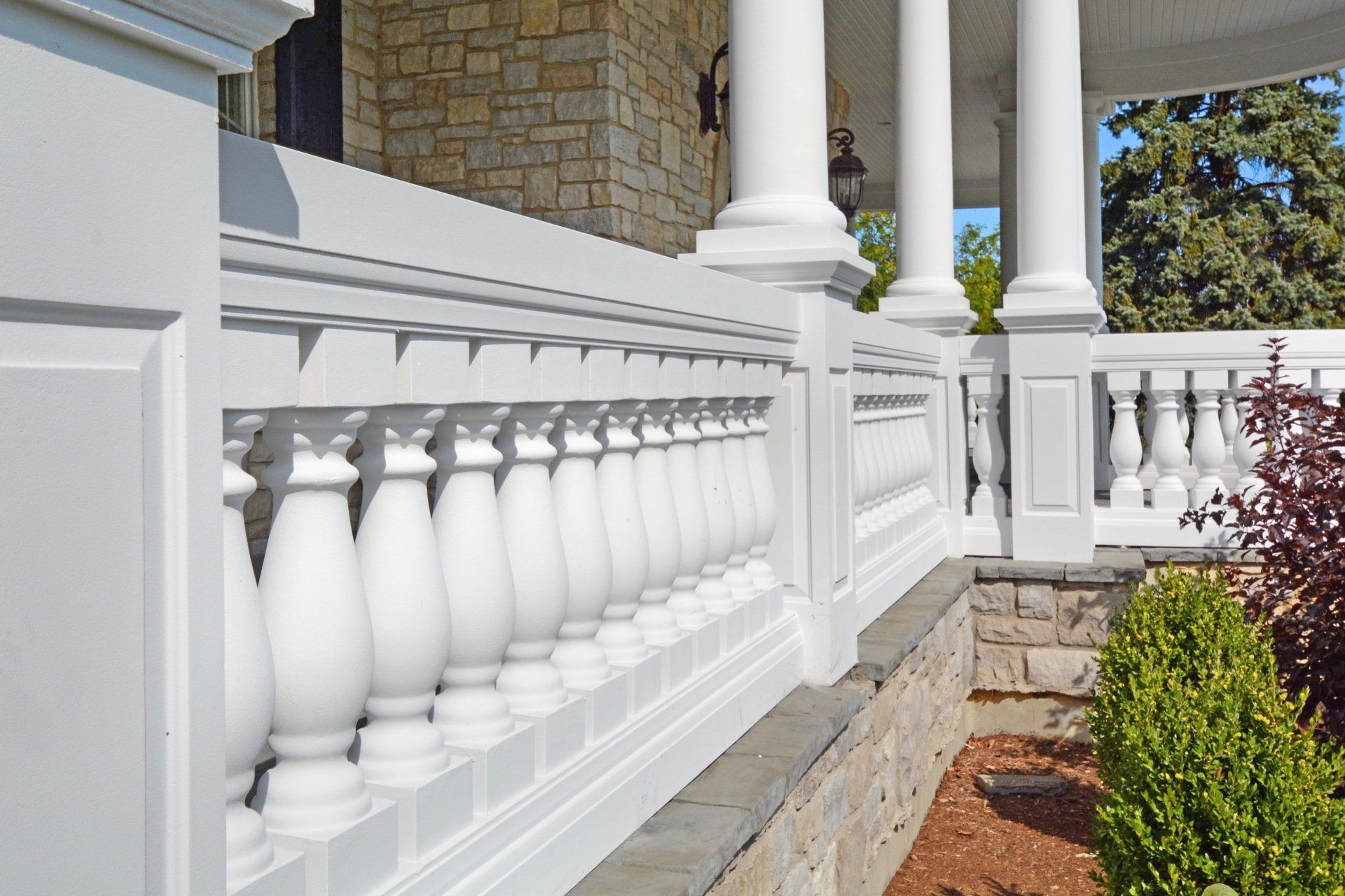 a white railing with columns on the side of a house