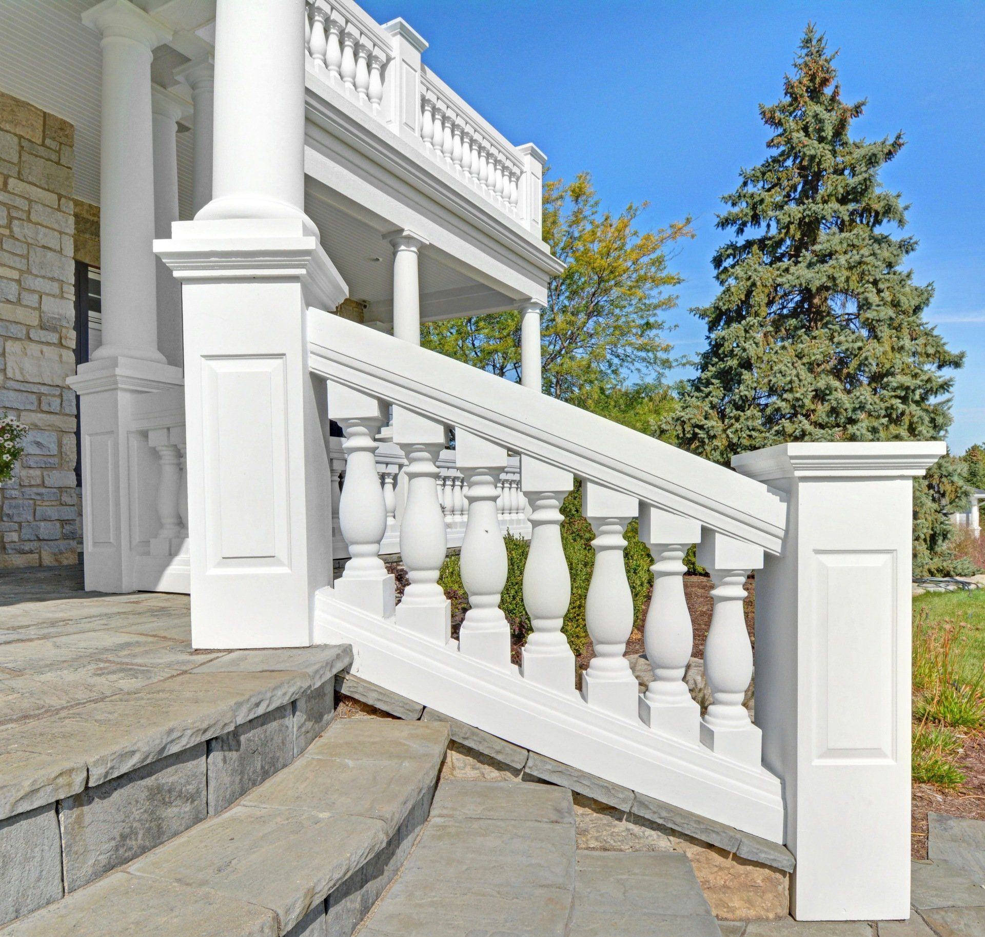 a white railing leading up to a porch of a house