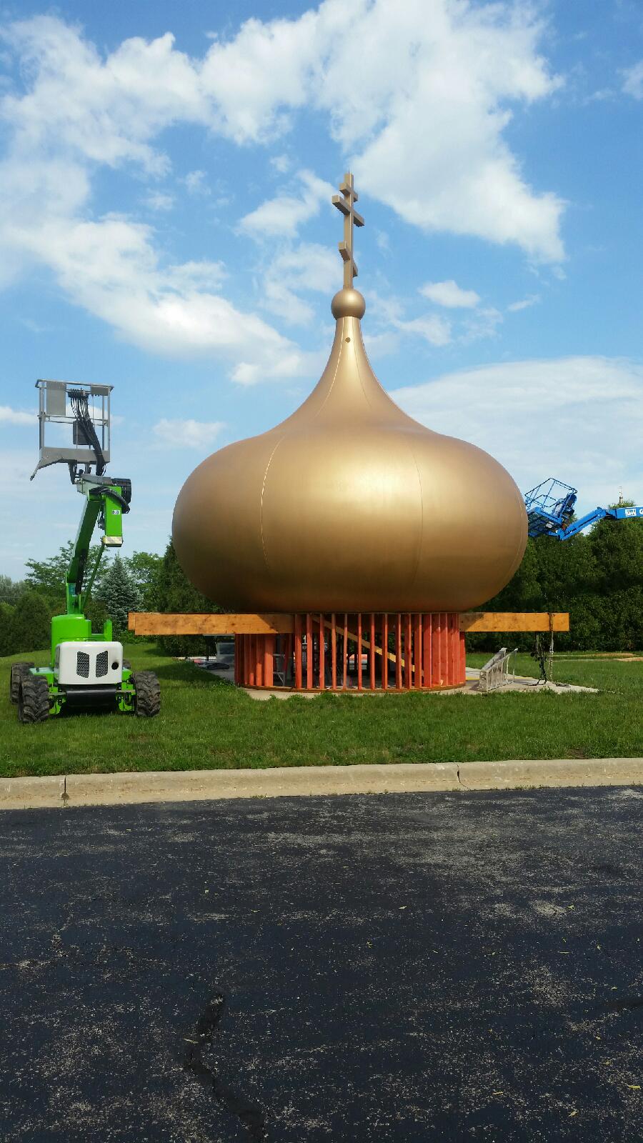 a large gold dome with a cross on top is being built